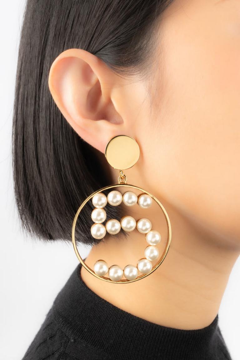 Chanel - Golden metal clip-on earrings with costume pearls. 1987 Spring-Summer Collection.

Additional information: 
Condition: Very good condition
Dimensions: Height: 8 cm
Period: 20th Century

Seller Reference: BOB93