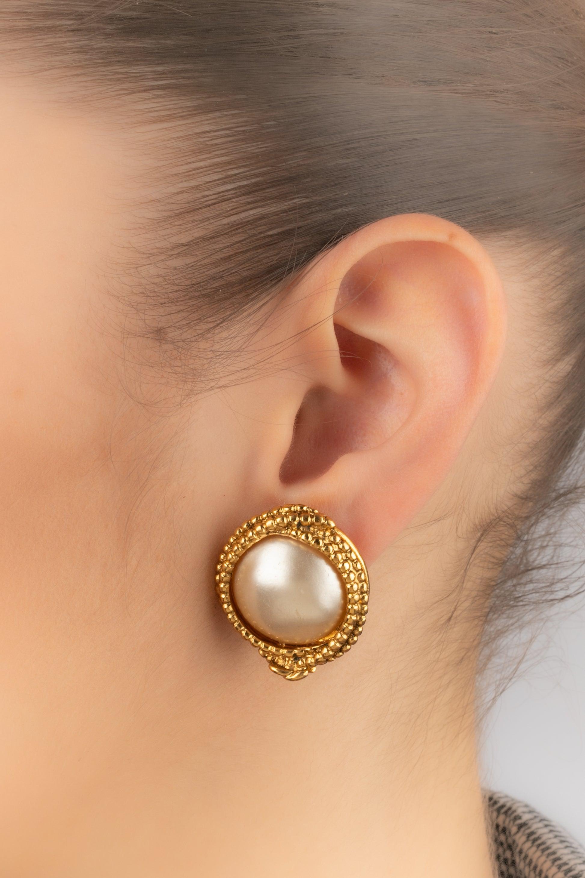 Chanel - (Made in France) Orecchini a clip in metallo dorato con cabochon di perle in costume. Collezione Autunno-Inverno 1996.

Informazioni aggiuntive:
Condizioni: Ottime condizioni
Dimensioni: Diametro: 3 cm
Periodo: 20° secolo

Riferimento del