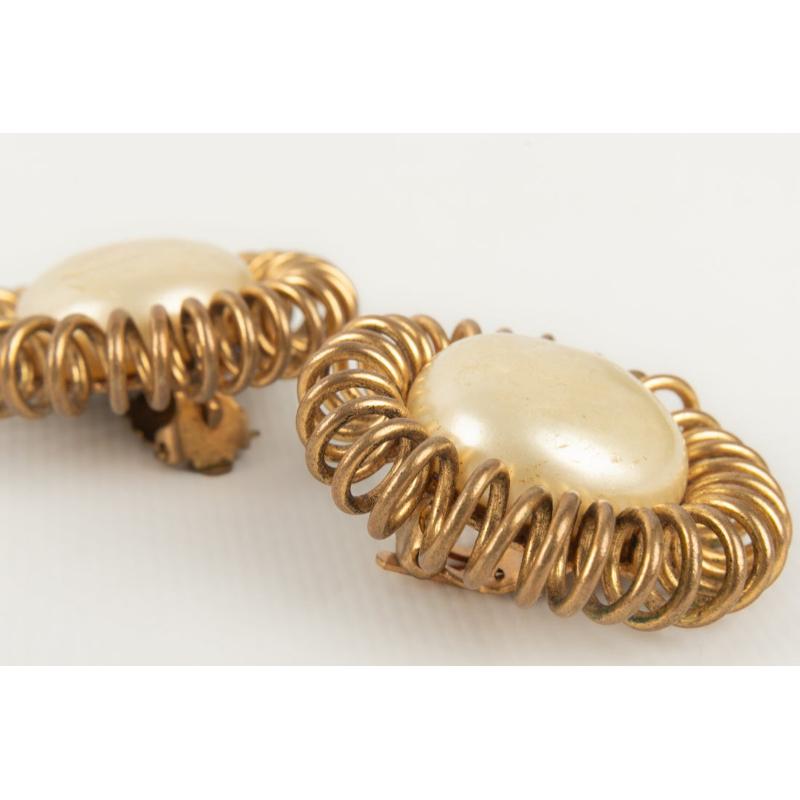 Chanel - Golden metal clip-on earrings with costume pearly cabochons. Haute Couture Collection from the Coco era, signed with a cc on the clip.

Additional information:
Condition: Good condition
Dimensions: Diameter: 4 cm

Seller Reference: BOB125