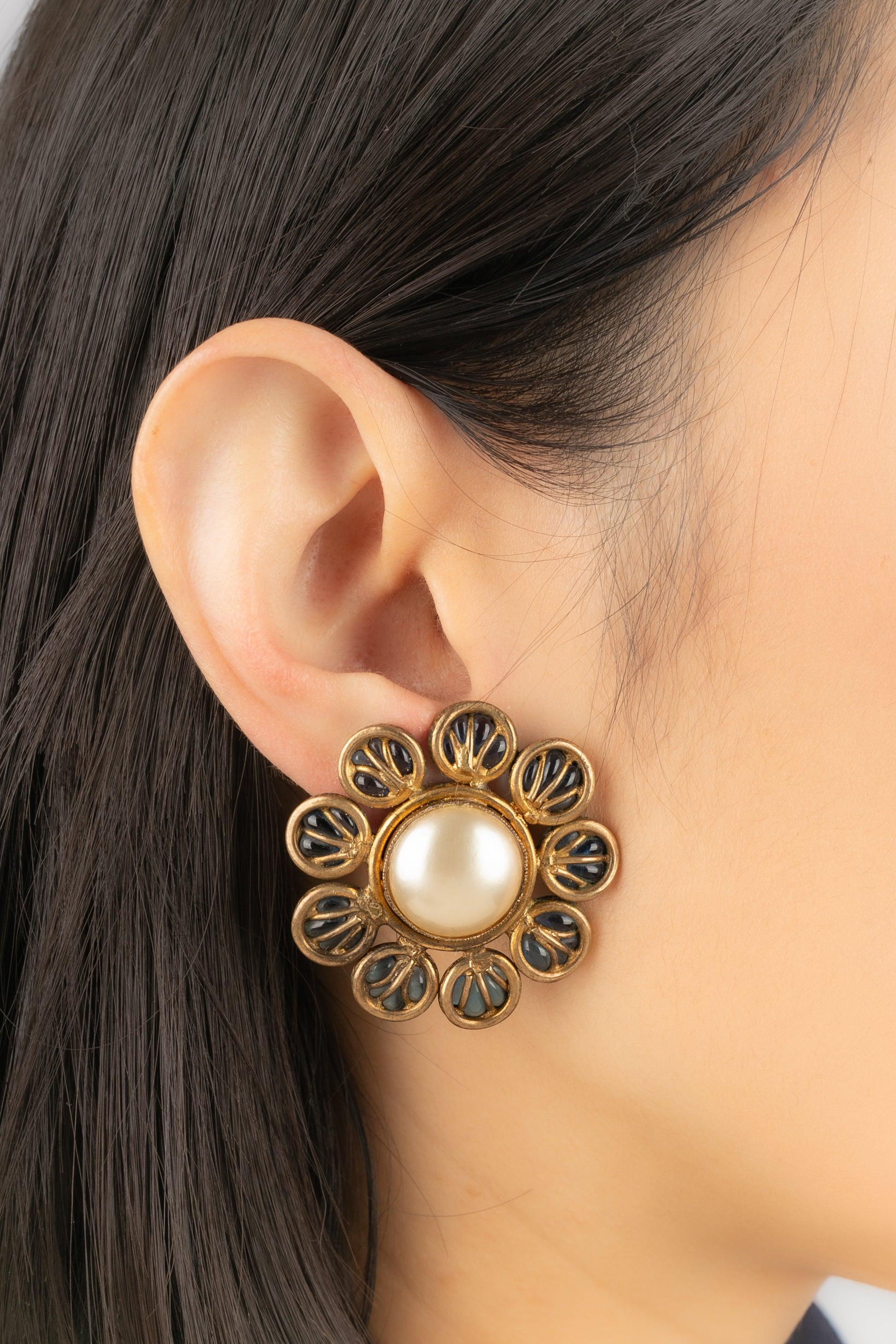 Chanel - (Fabriqué en France) Boucles d'oreilles à clip en métal doré avec pâte de verre bleue et cabochons nacrés fantaisie. Bijoux gravés avec le S de Sales.

Informations complémentaires :
Condit : Très bon état.
Dimensions : Hauteur : 4