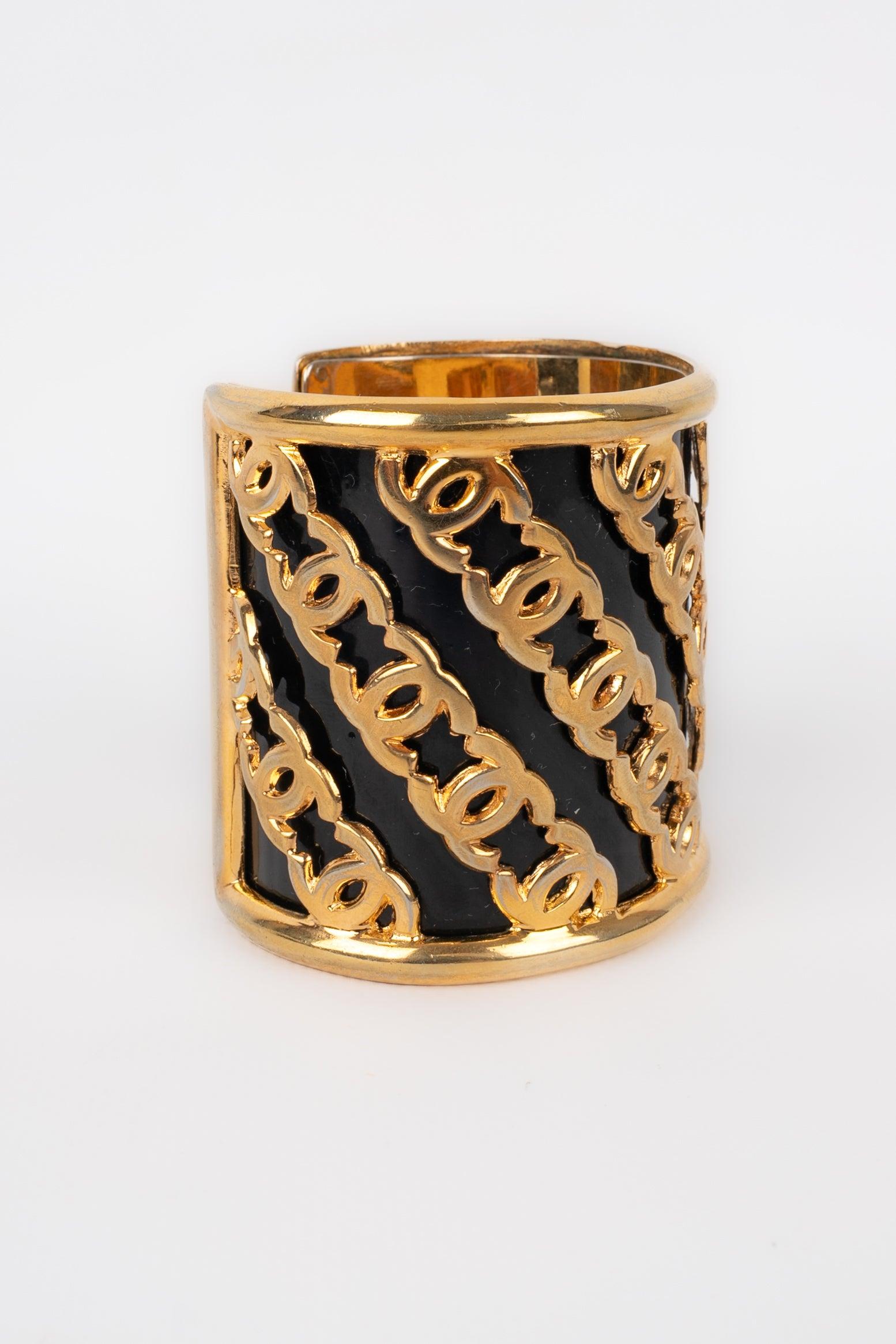 Chanel - Manschettenarmband aus goldenem Metall, schwarz emailliert.
 
 Zusätzliche Informationen: 
 Zustand: Sehr guter Zustand
 Abmessungen: Umfang des Handgelenks: 14 cm - Höhe: 6 cm
 
 Sellers Referenz: BRAB44