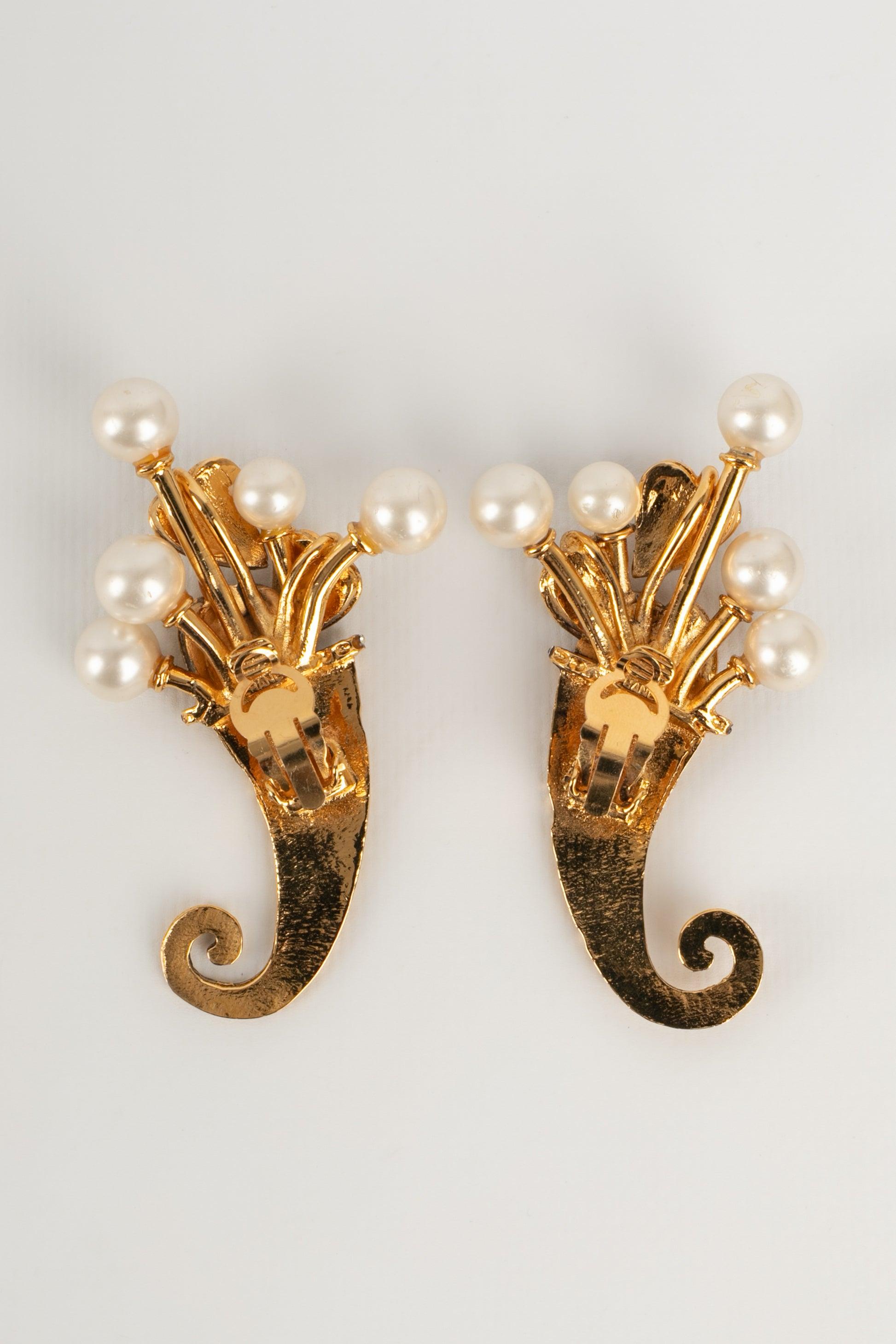 Chanel - Golden metal earrings with costume pearls and rhinestones.

Additional information:
Condition: Very good condition
Dimensions: Height: 7.5 cm

Seller reference: BOB147