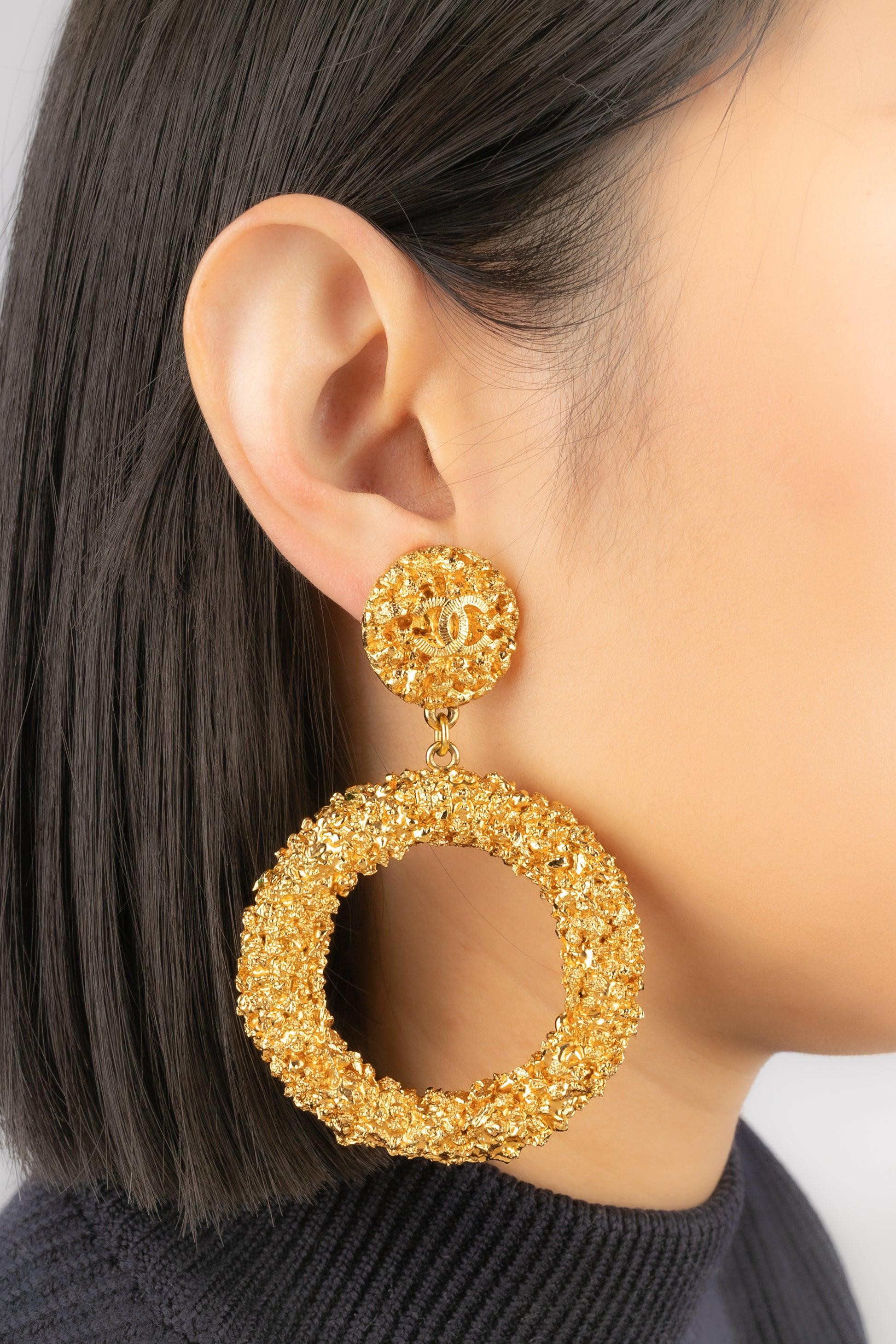 Chanel - (Made in France) Orecchini a cerchio in metallo dorato. Collezione Cruise 1993, sotto la direzione artistica di Karl Lagerfeld.

Informazioni aggiuntive:
Condizioni: Ottime condizioni
Dimensioni: Altezza: 8,5 cm
Periodo: 20°
