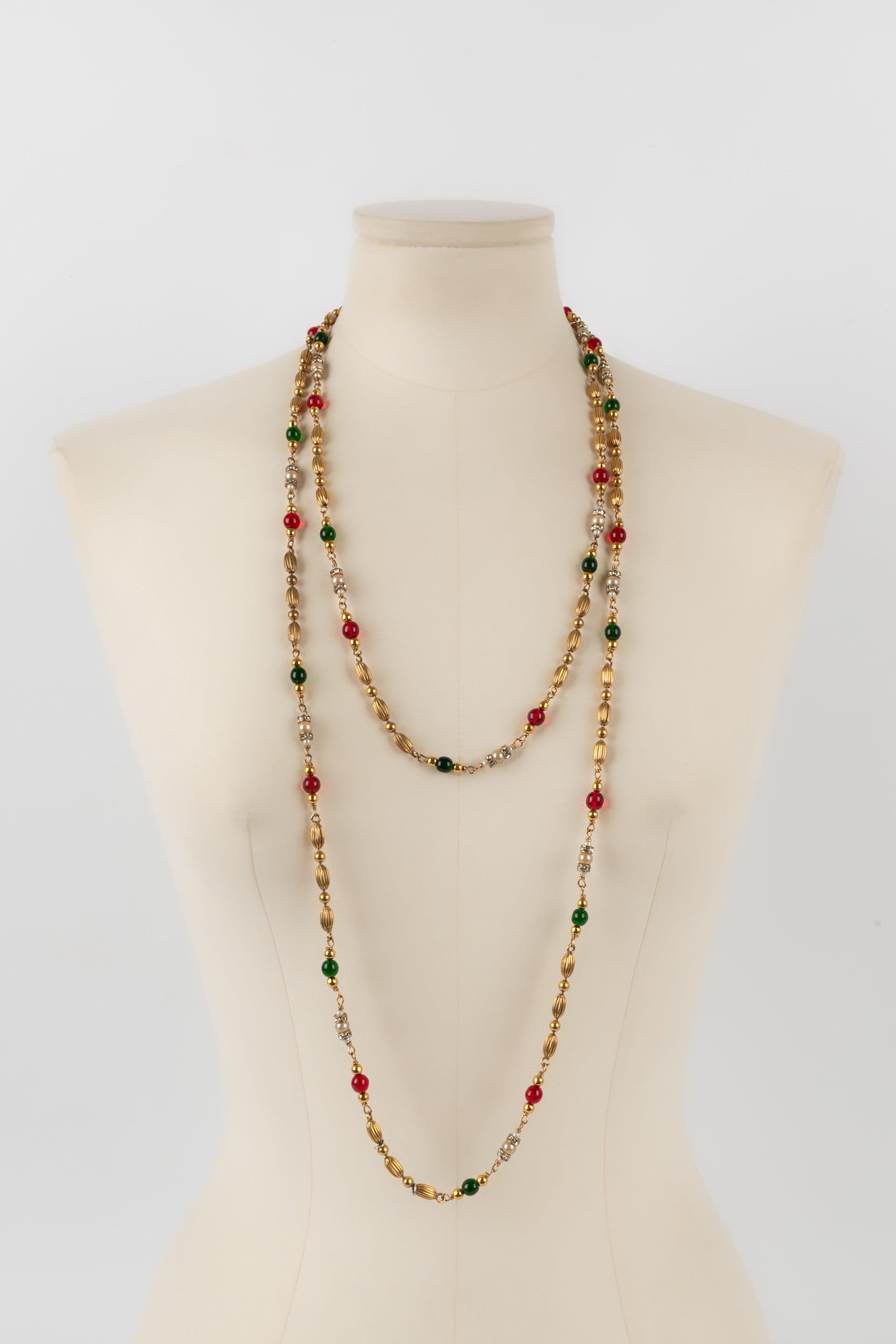 Chanel - (Made in France) Golden metal sautoir with metallic pearls, rhinestone rings, and glass pearls in red, green, and pearly tones. Jewelry from the 1960s.

Additional information:
Condition: Very good condition
Dimensions: Length: 165