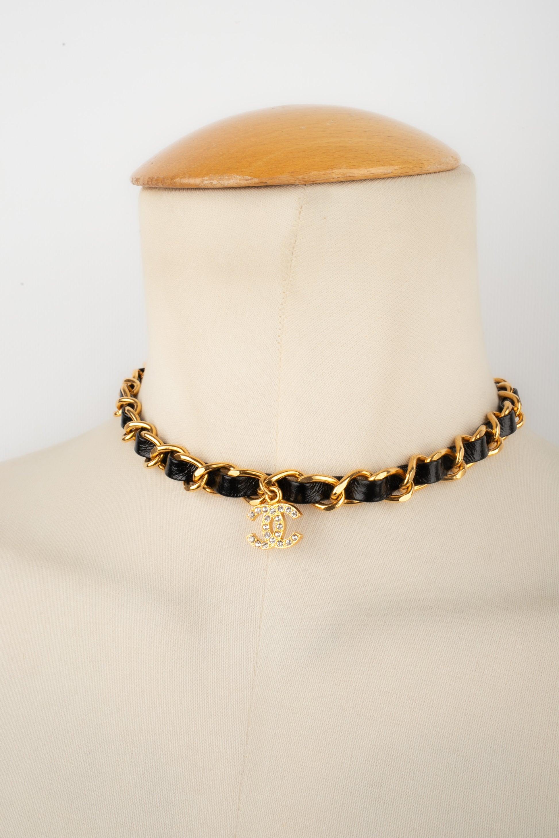 Chanel - (Made in France) Golden metal short necklace with patent leather. The cc pendant is ornamented with rhinestones. 1995 Spring-Summer Collection.

Additional information:
Condition: Very good condition
Dimensions: Length: from 33 cm to 39