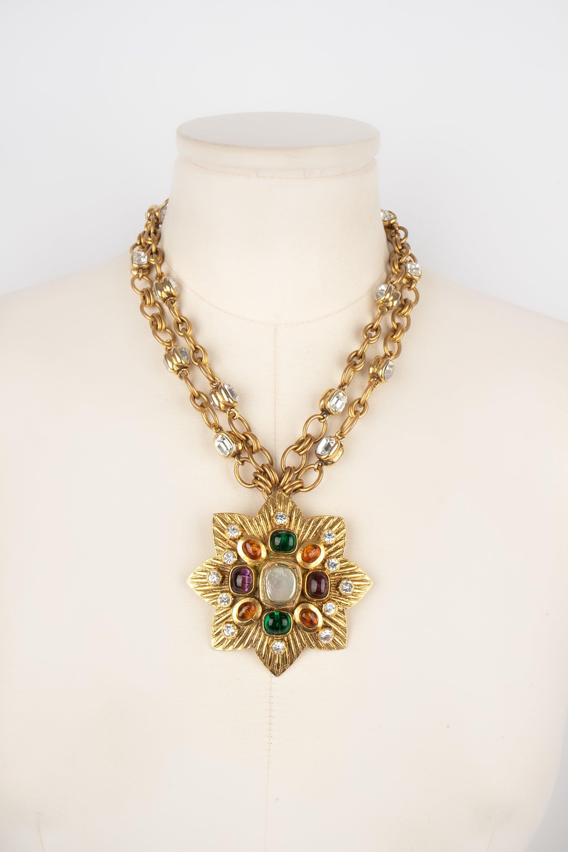 Chanel- (Made in France) Golden metal two-row necklace with rhinestones and with a golden metal pendant ornamented with rhinestones and glass paste. 1985 Collection.

Additional information:
Condition: Very good condition
Dimensions: Length: 44