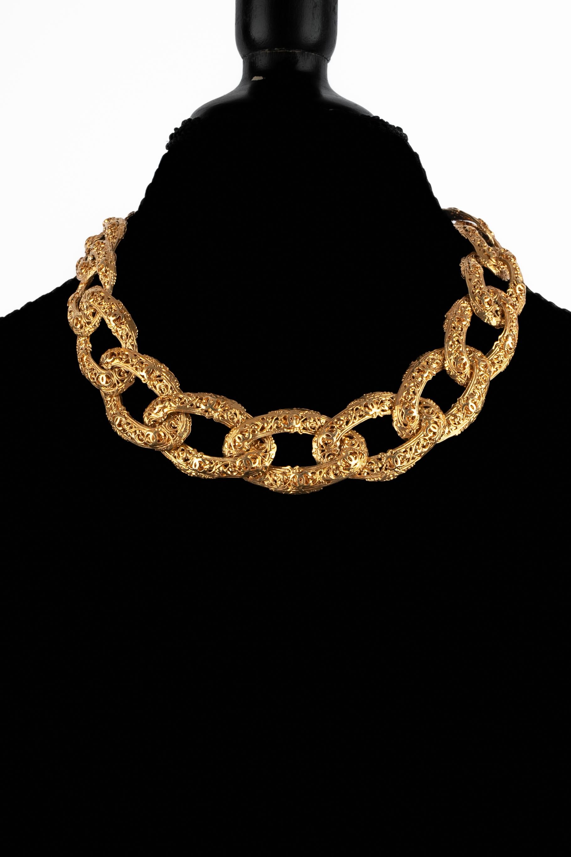 CHANEL - (Made in France) Golden metal necklace made of flat links interlaced representing tiny cc logos. A 2cc9 Collection from the early 1990s, designed under the artistic direction of Karl Lagerfeld.

Condition:
Very good