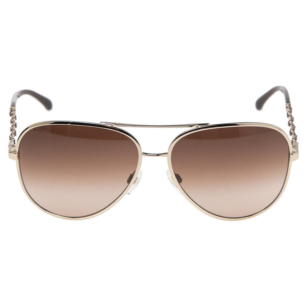 Wear these gorgeous aviators from Chanel and watch heads turn. Crafted from gold-tone metal, they are accented with chain-link and leather woven arms. These sunglasses are fitted with gradient lenses that provide UV protection.

Includes: Original