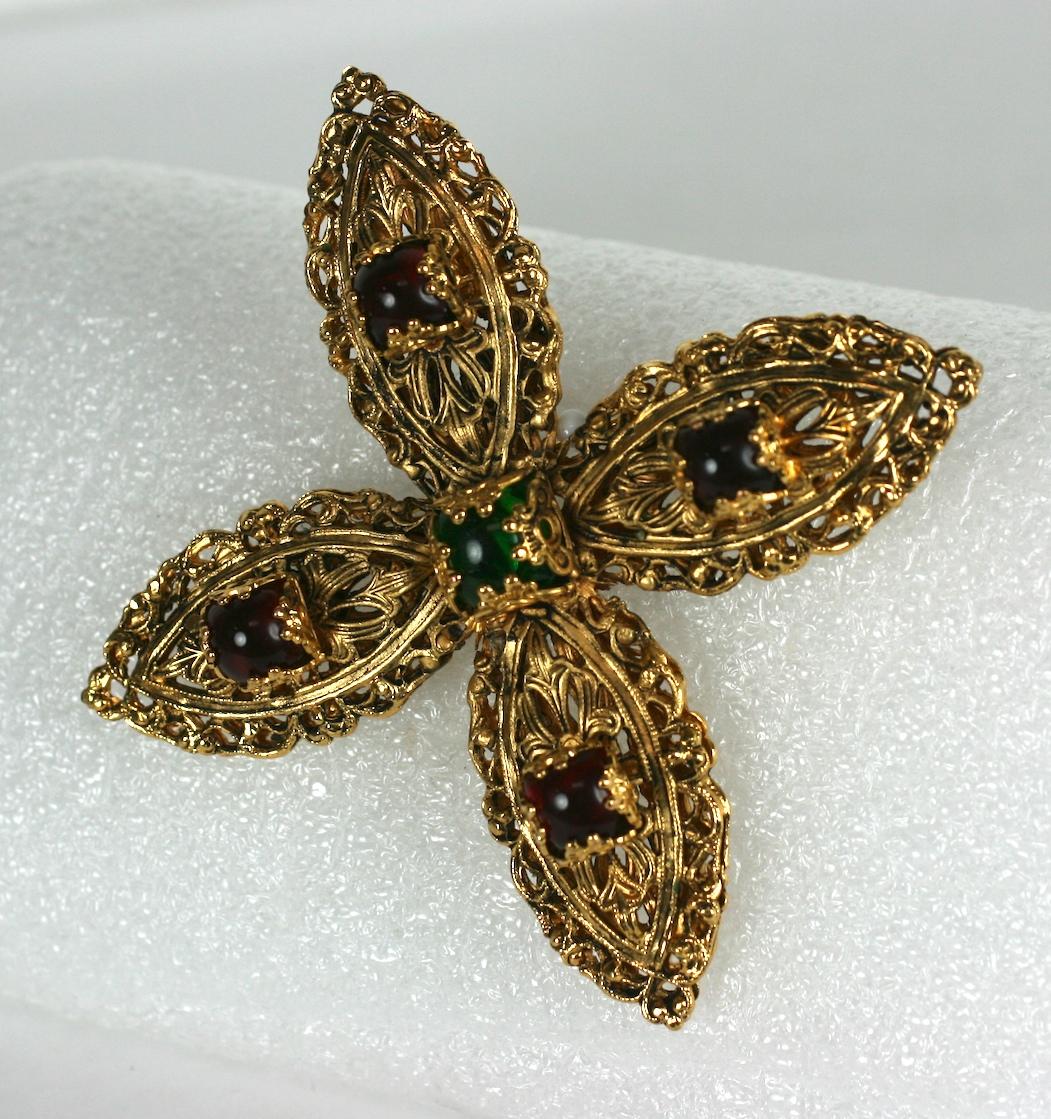 Wichtige Maison Goossens für Chanel filigrane Brosche mit byzantinischem Kreuz. von  vergoldete kreuzförmige Filigrane und quadratische Cabochon-Steine im Gelee-Schliff aus Smaragd- und Rubin-Pate de Verre. Frühe französische Posaunenklammer.
1960s.