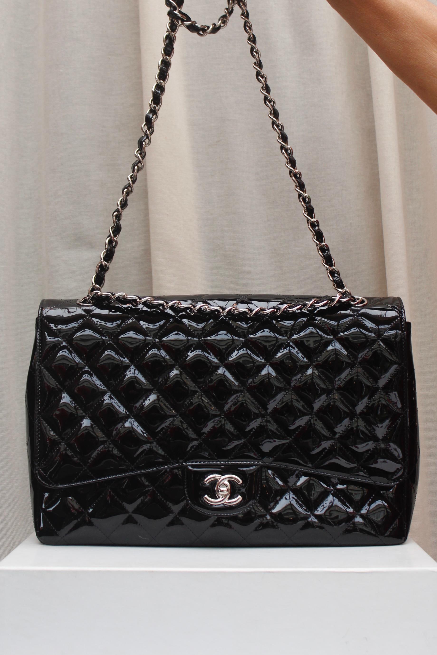 CHANEL (Made in Italy) Gorgeous large black quilted patent leather. It can be worn over the shoulder or cross-body, thanks to two silver plated shoulder straps entwined with black patent leather. One patch pocket at the back. Silver plated