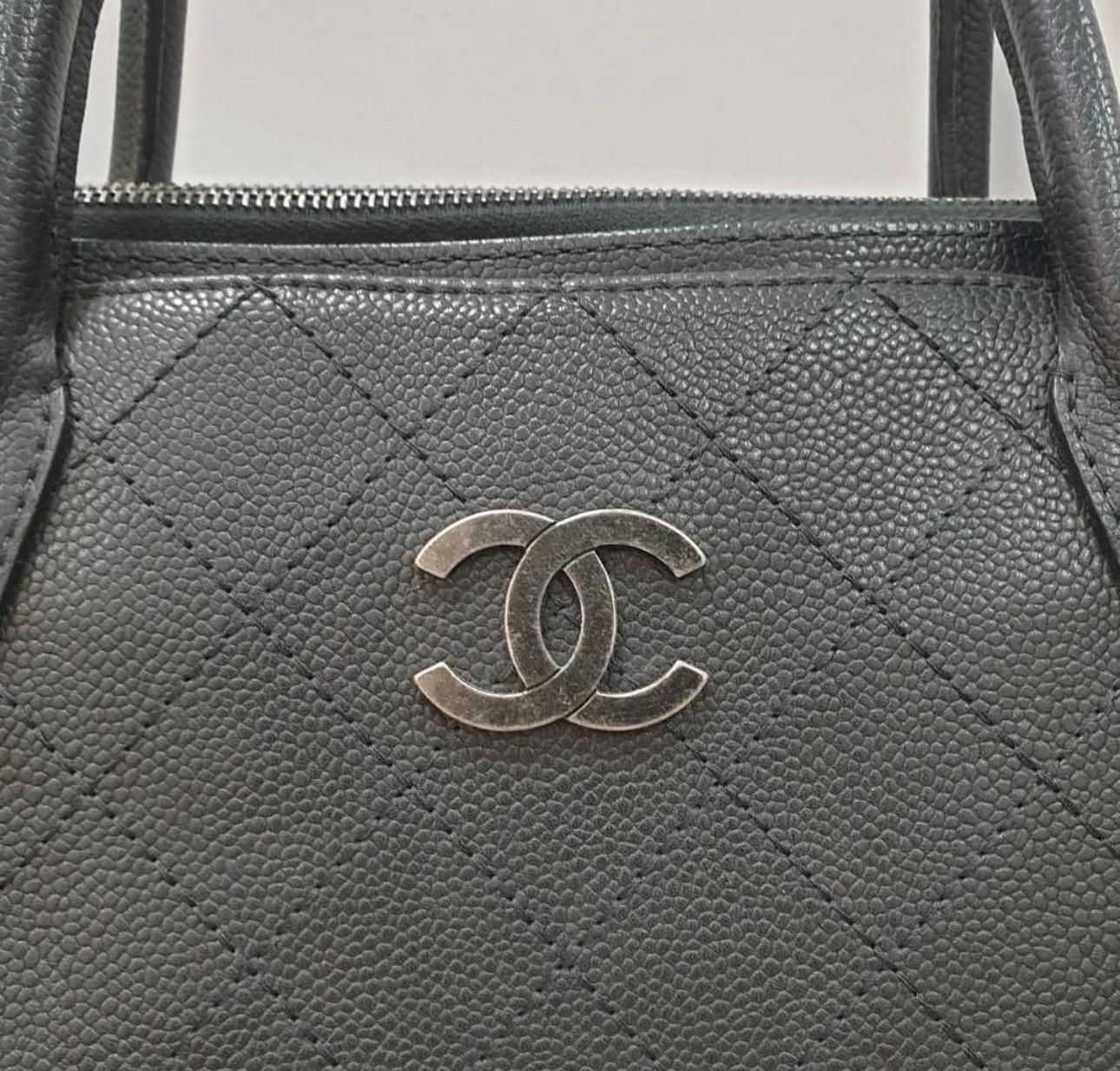 This stylish tote is beautifully crafted of luxurious grained vegetal dyed stitched calfskin leather. The bag features ruthenium chain link leather threaded shoulder straps. The top is open to a partitioned black fabric interior with a central