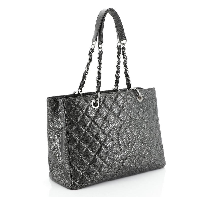 This Chanel Grand Shopping Tote Quilted Caviar, crafted in metallic gray quilted caviar leather, features woven-in leather chain straps with leather pads, exterior back pocket, and gunmetal-tone hardware. It opens to a neutral fabric interior with