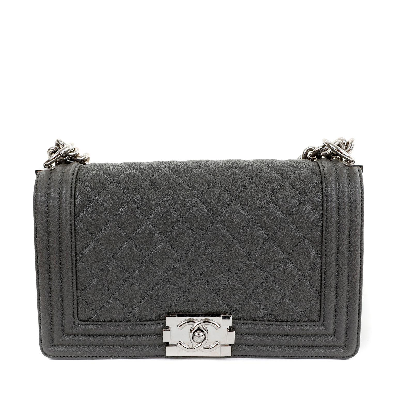 This authentic Chanel Graphite Caviar Medium Boy Bag is in pristine condition. The updated design is structured and edgy with a versatility that makes it extremely popular.  Neutral graphite grey caviar leather is textured and durable. Further