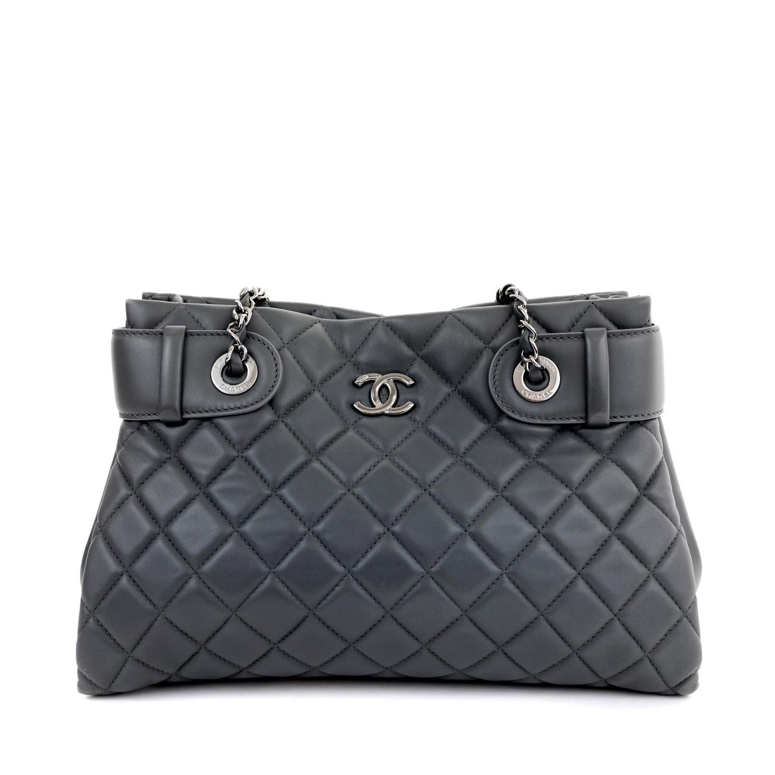 This authentic Chanel Graphite Lambskin Small Tote is in pristine unworn condition.  Perfect for every day, the simple silhouette carries all the essentials with an understated stylish flair.

Neutral dark graphite lambskin is quilted in signature
