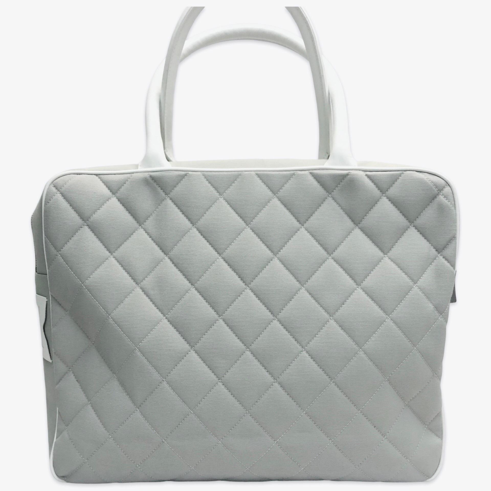 - This sporty and chic Chanel canvas boston style bag in gray. It was made in between Year 2000 to 2002. It is light weighted. 

- Featuring white leather 