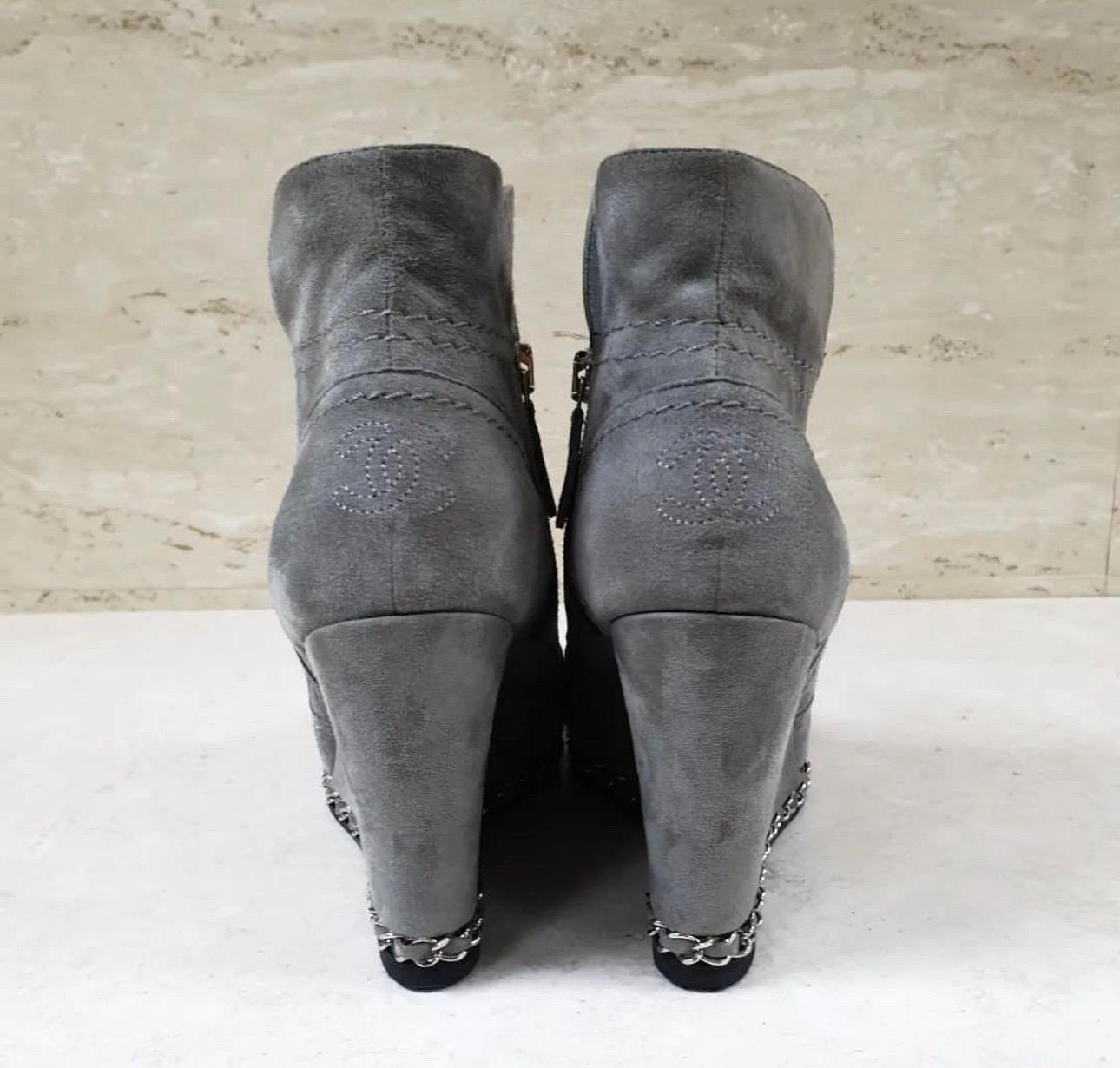 From the Fall 2011 Collection. 
Grey suede Chanel ankle boots with black leather cap toes, chain-link trim, interlocking CC accents at counters, covered wedge heels and zip closures at sides
Very good condition. Slight signs of wear.
Sz.38,5
No box.