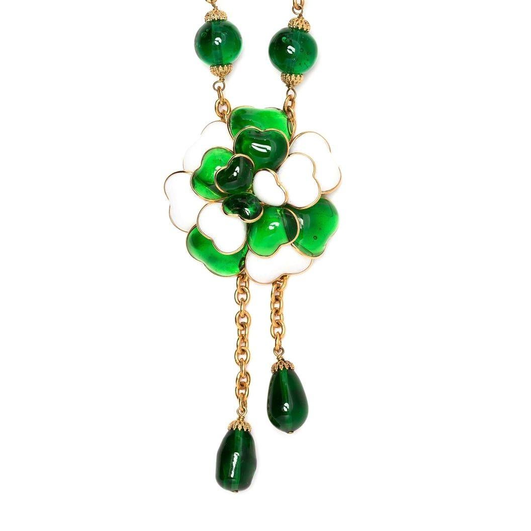 Designed with baroque detailing, this vintage pre-owned Chanel by Gripoix necklace form the 1980's displays large green beads against a chunky gold-tone chain. The focus of the necklace is a large green and white camellia flower, a symbol used