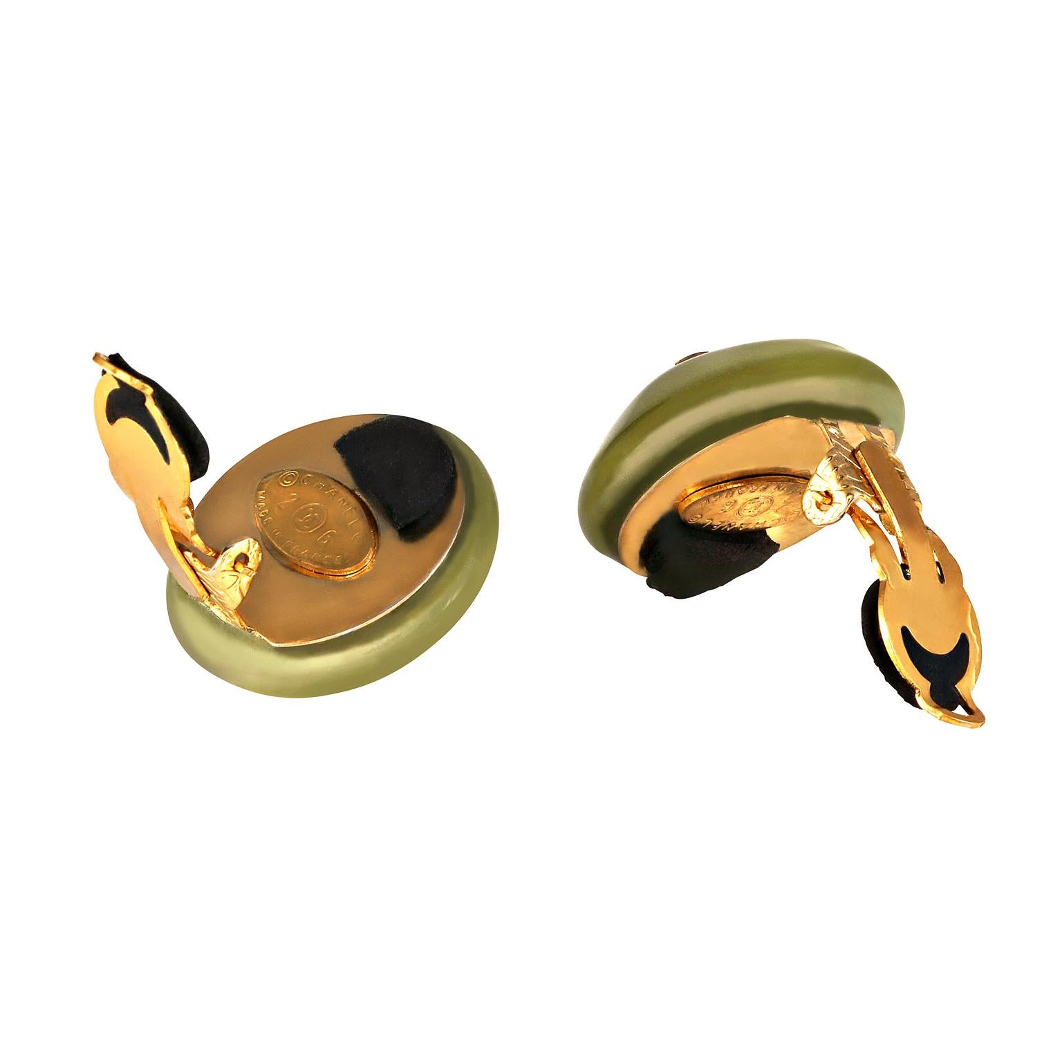 These authentic Chanel Green CC Button Earrings are in excellent condition from the late 1980’s.  Avocado green resin round button style earrings have tiny gold flecks and an interlocking CC centered on each.  Clip on closure.  Made in France. 

