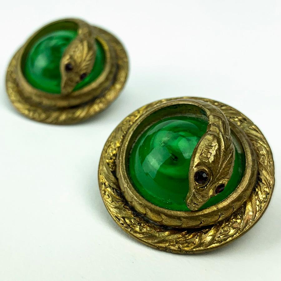 The earrings are from Maison CHANEL. These are two balls of green glass paste, each encircled by a cobra metal hammered and gilded with fine gold.
The earrings are in very good condition. We have here an exceptional piece knowing that the clips go