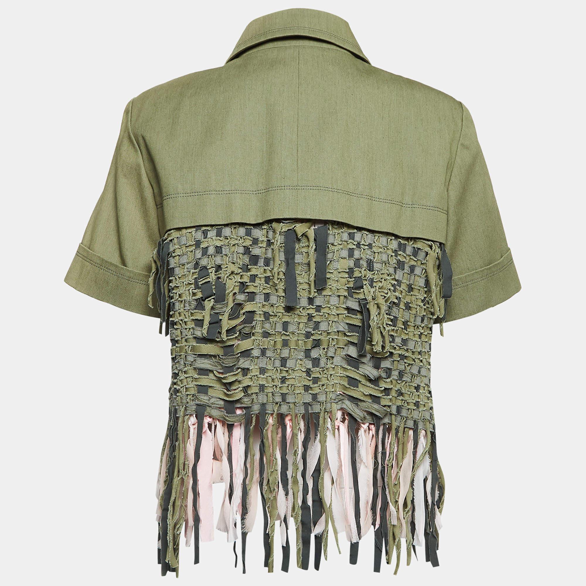 The Chanel jacket exudes sophistication with its luxurious green gabardine fabric. Adorned with intricate fringe detailing, it offers a unique blend of elegance and contemporary style, perfect for making a statement with timeless charm and