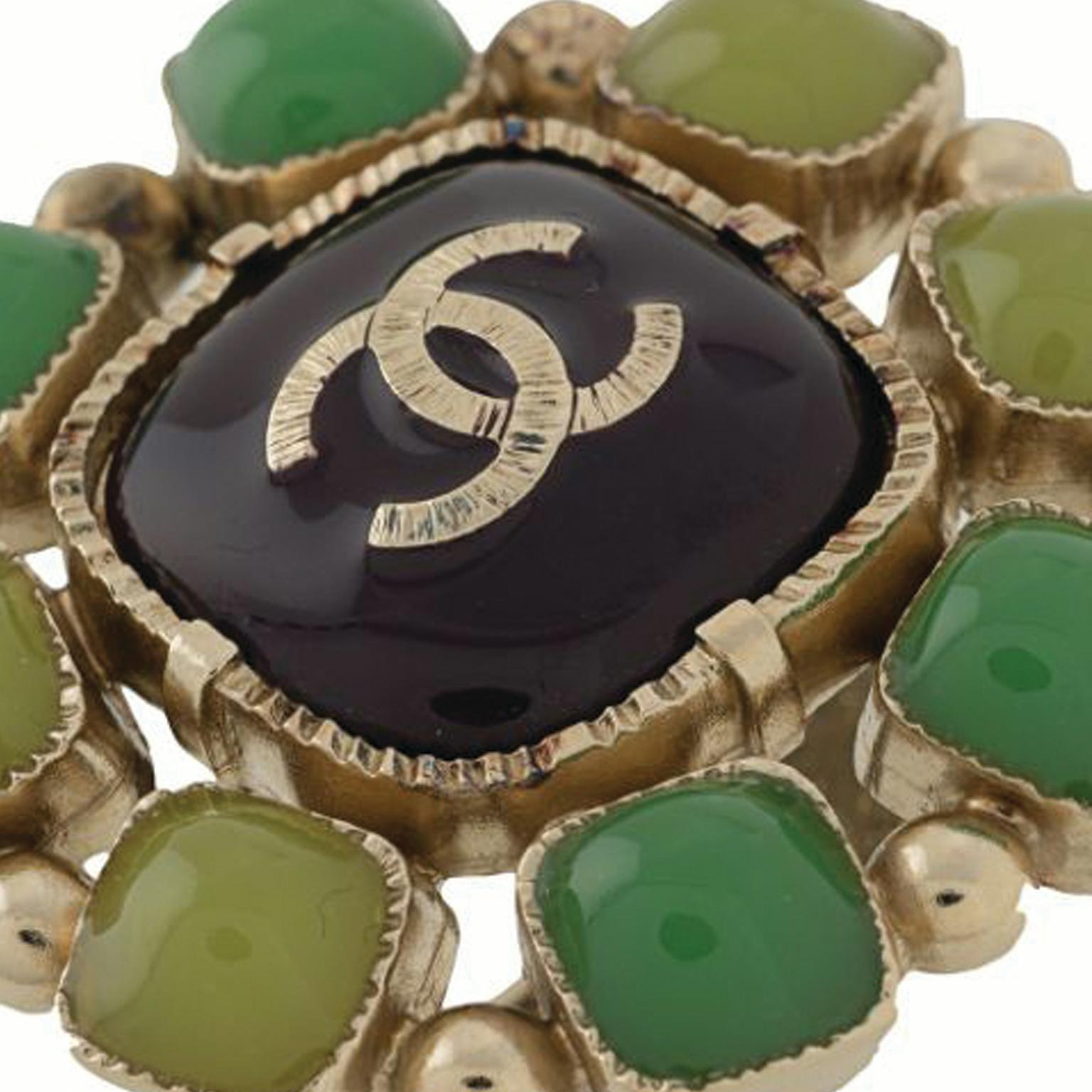 A bold and striking ring from Chanel. Crafted from stones in hues of green on a gold-toned metal, with the iconic interlocking CC logo placed centrally for all to admire.

Colour: Green & Gold

Composition: Metal & Stone

Condition: Excellent