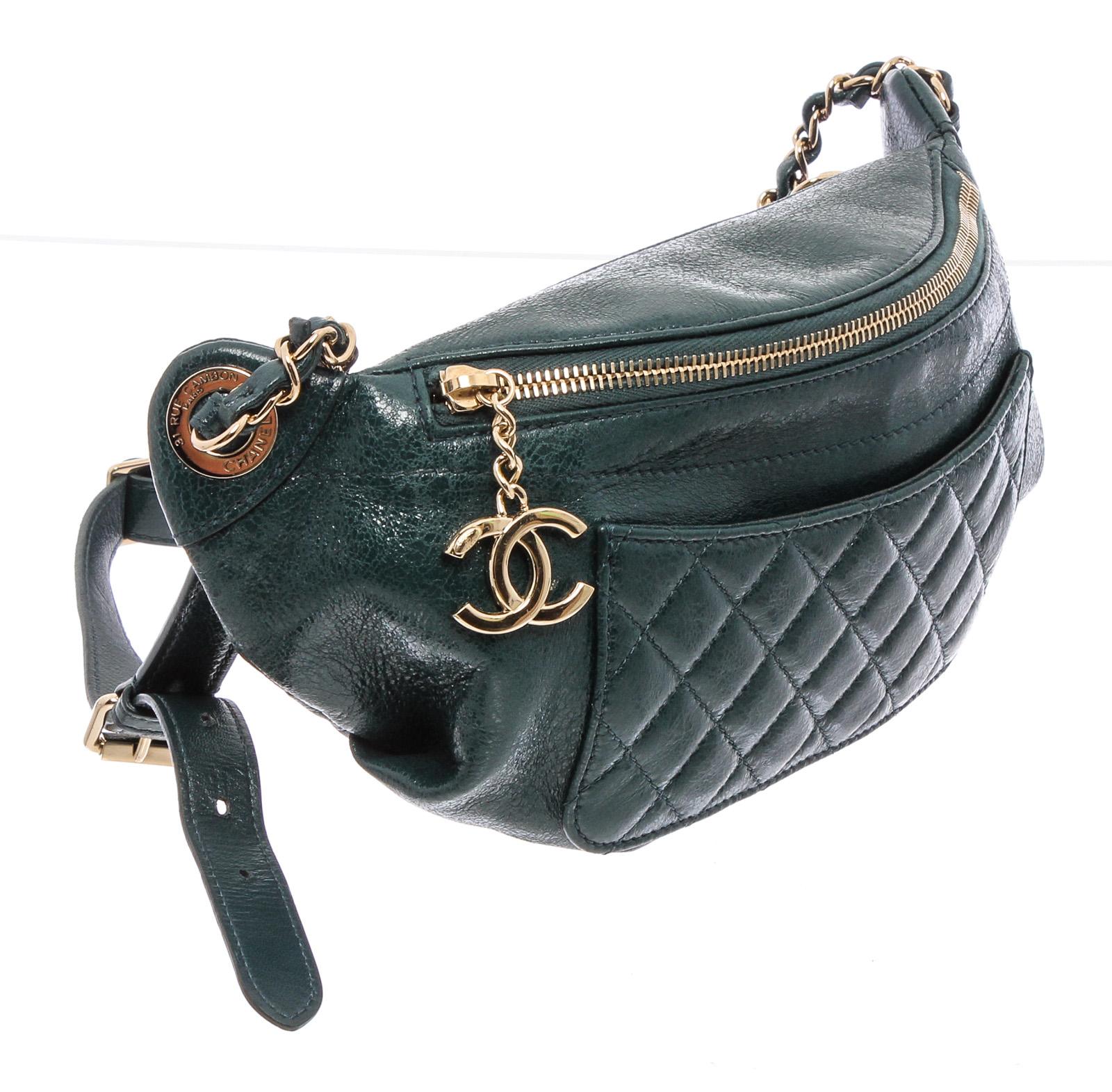 Green lambskin Chanel Bi Classic waist bag with gold-tone hardware, single adjustable flat waist strap with chain-link accents, tonal quilted lambskin trim, dual exterior pockets; one with zip closure, tonal grosgrain lining, single interior slit