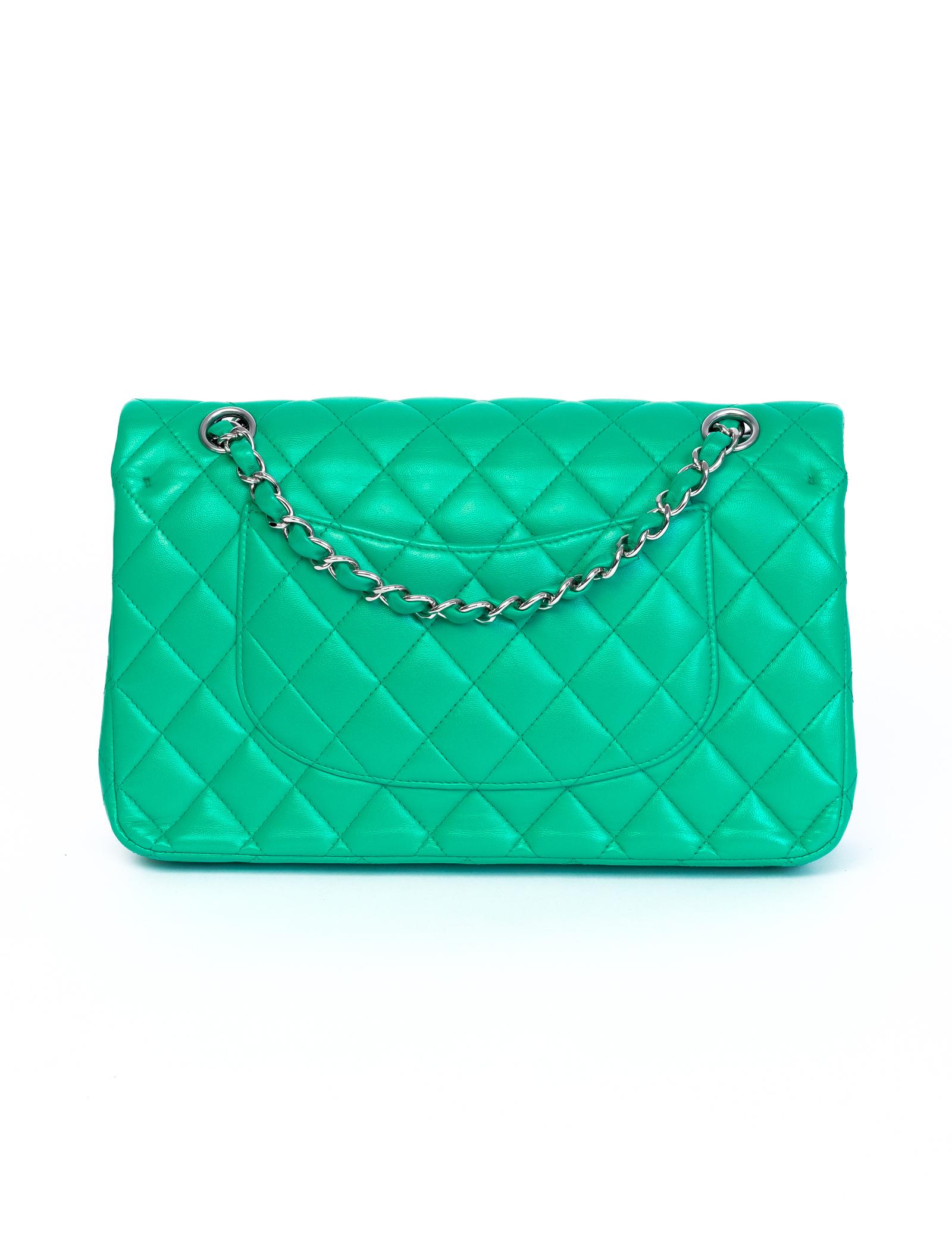 This Chanel Double Flap Bag is made with green lambskin leather with diamond quilting. Featuring sliver toned hardware, a silver toned chain interlaced with leather, an interlocking CC turn lock clasp, and a half moon back slip pocket. The interior