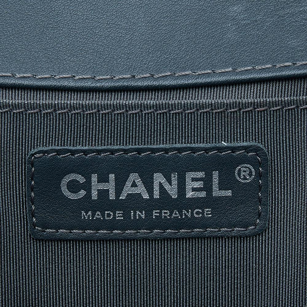 This medium Boy Flap bag from the House of Chanel is truly a pièce de résistance in the world of luxury fashion. It is crafted using grey, olive green quilted Caviar leather with a CC accent placed on the front. This bag is held by a sturdy chain