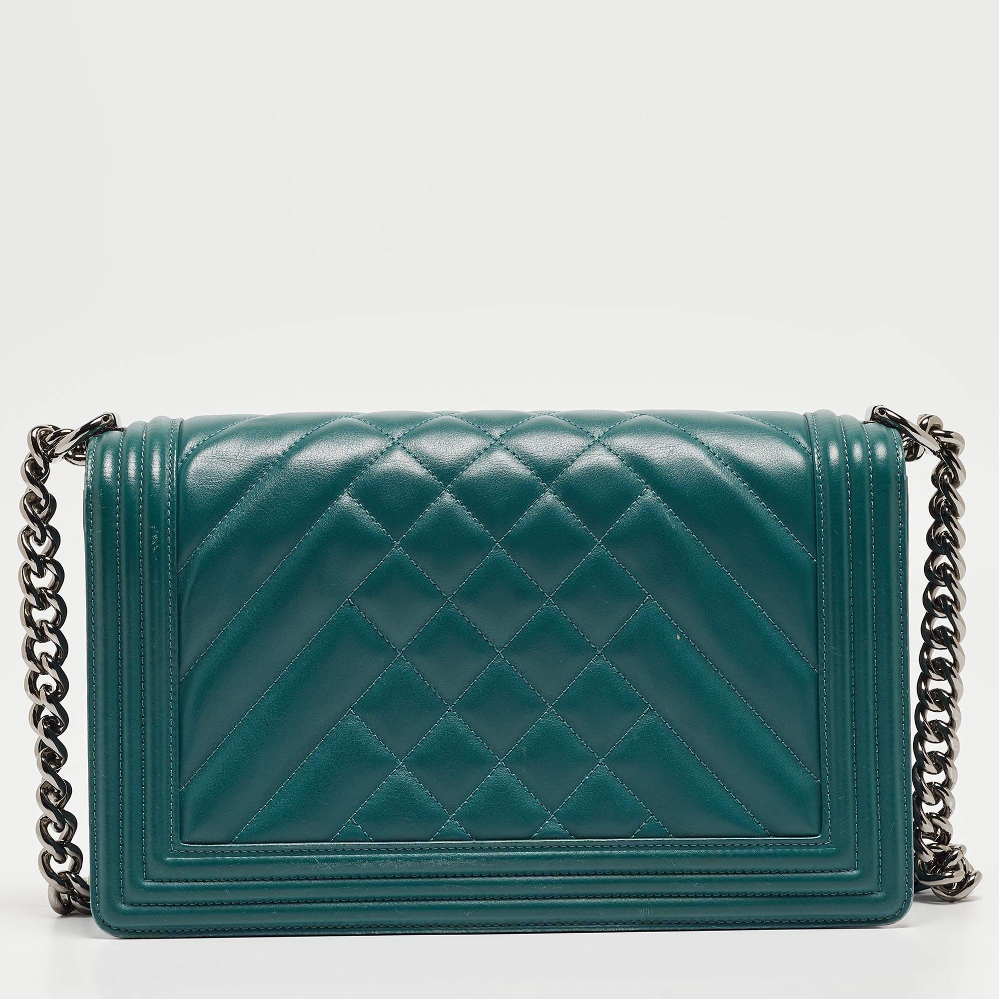 The Chanel New Medium Boy Bag exudes timeless elegance with its vibrant green hue and meticulously stitched quilted leather. The iconic Boy bag design features a silver-tone chain strap and the distinctive Boy clasp, making it a luxurious and