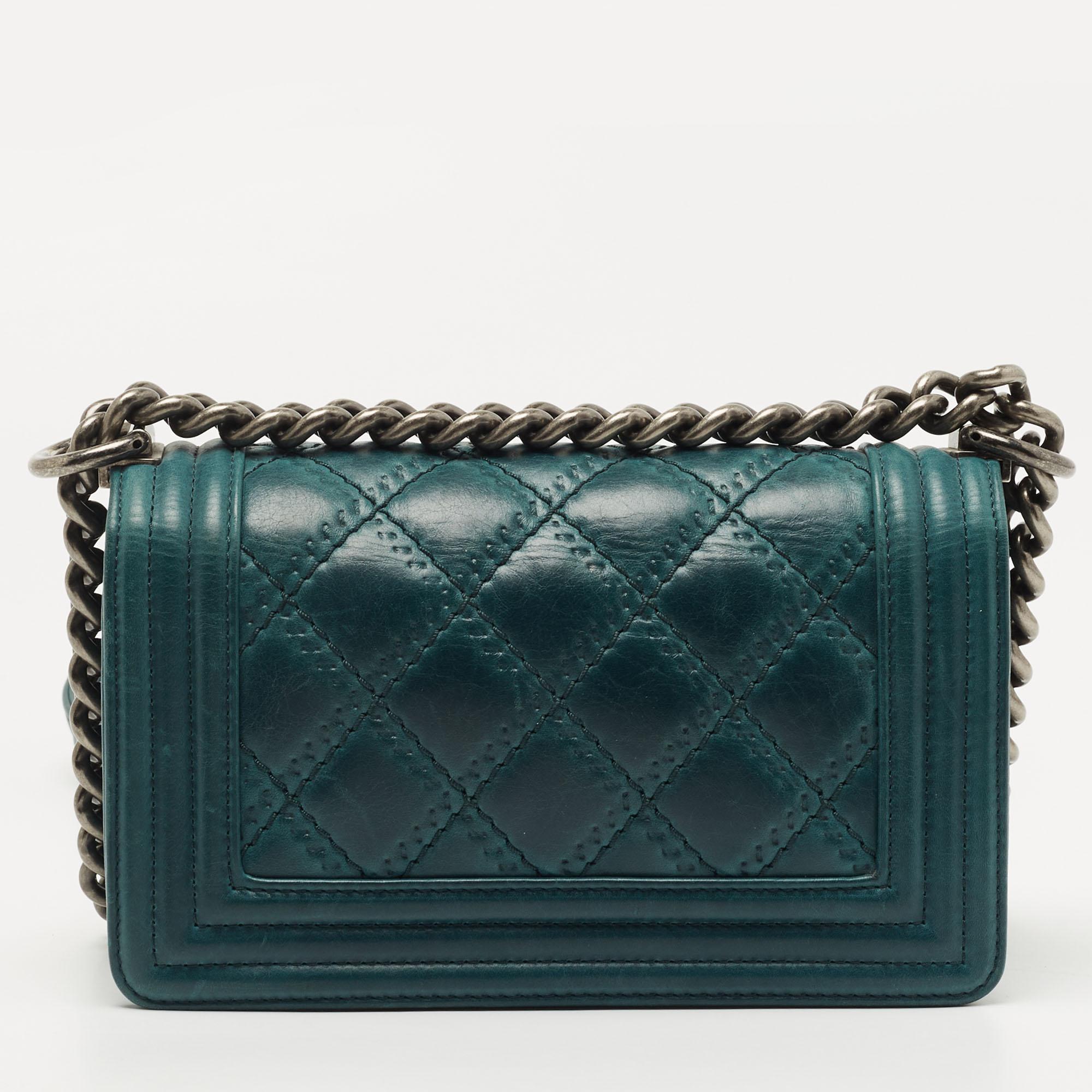 The Boy flap bag is an icon of Chanel's. Here is a version in green leather. It brings the signature label within the fabric interior and the iconic CC push lock on the flap. The piece has dark ruthenium hardware and a shoulder chain link to place
