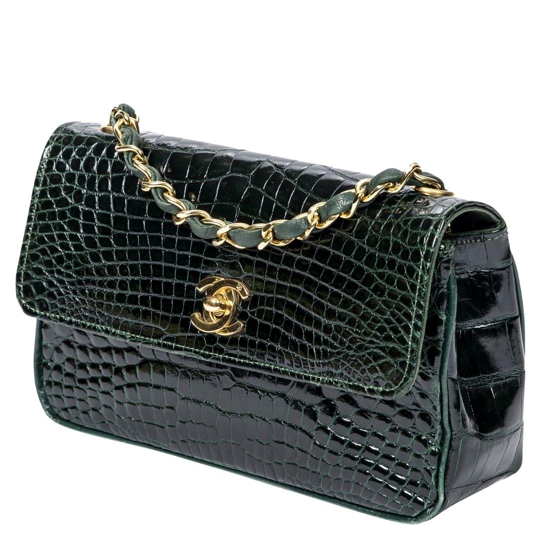 A rare green crocodile leather piece with a gold CC turnlock that opens to a leather interior with one slip pocket, combining luxury with functionality.

SPECIFICS
Length: 7.1
Width: 2
Height: 4.2
Strap drop: 21
Authenticity code: 1361196