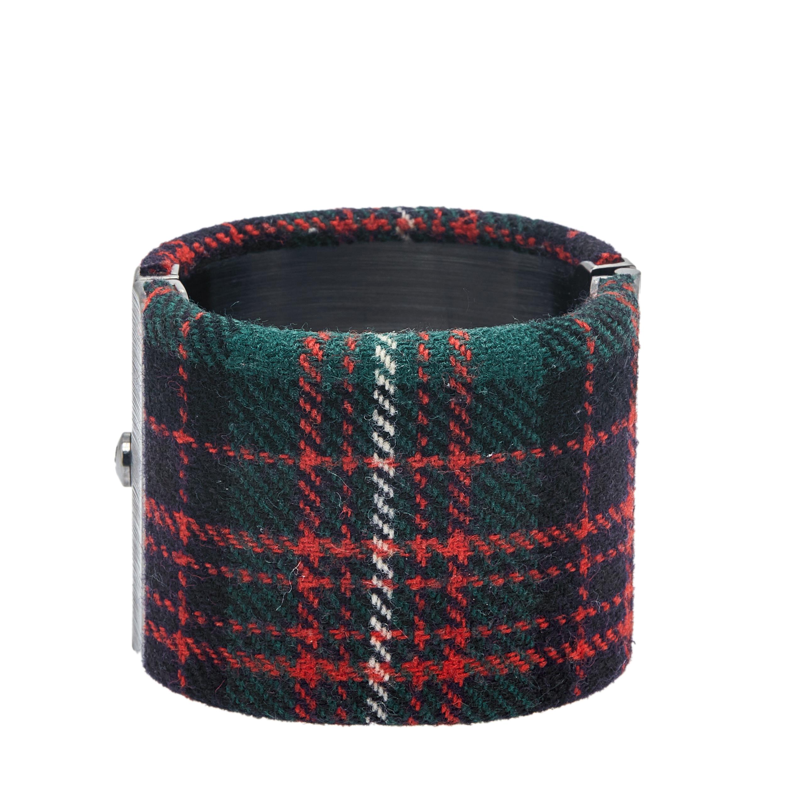 This cuff bracelet from Chanel, exuding a classic and feminine appeal, will be your new favorite statement accessory. It has a rock-chic design with an accentuating logo on the front featuring interlocking CCs. The tartan fabric body which is in