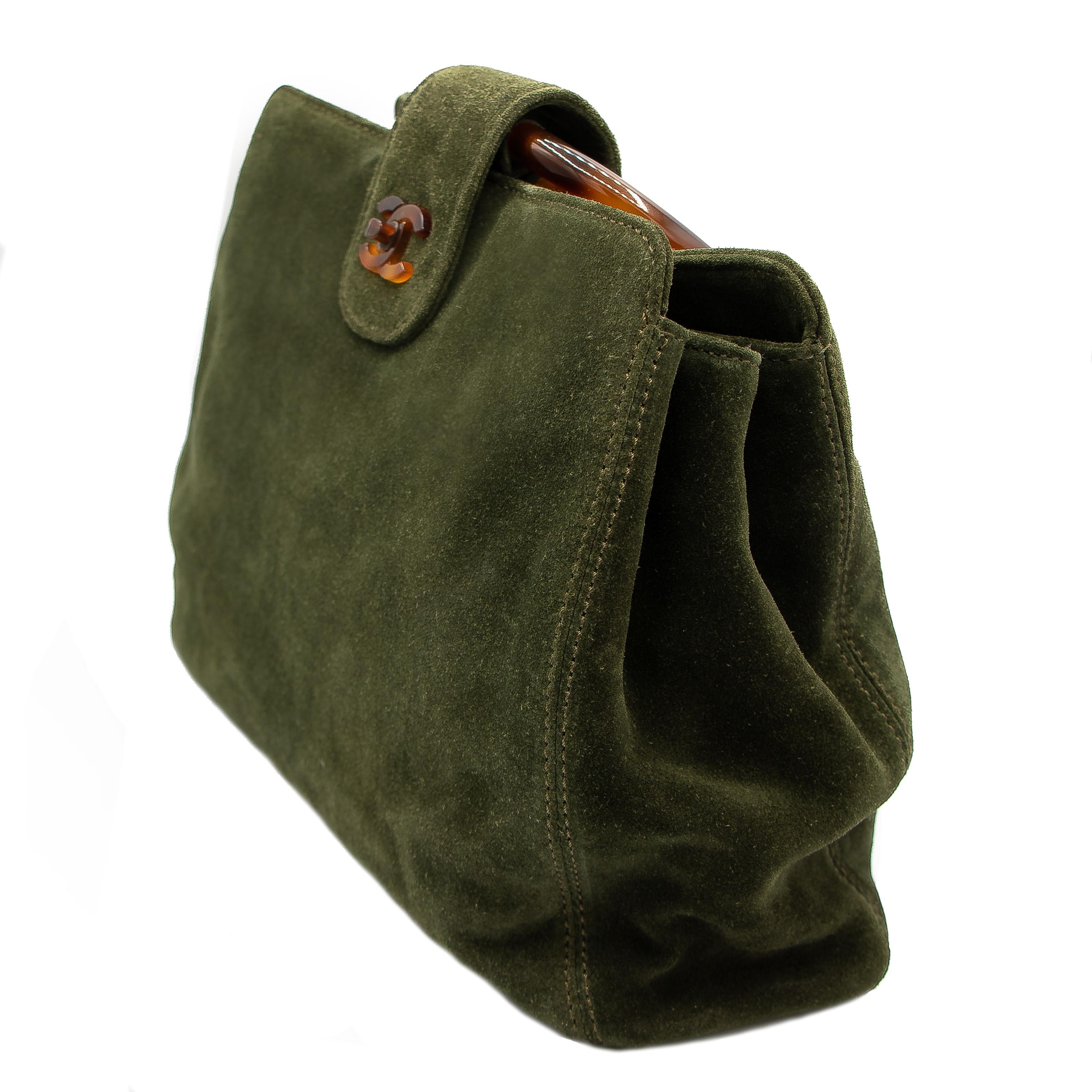 Stunning green suede handbag with lucite handles. This bag has 3 main pockets with the middle pocket with a suede appointment zipper. The lucite handles are very durable. The handles have caused some slight presses in the suede, but other than that