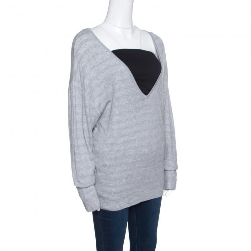 This knit sweater from Chanel will look fabulous when paired with smart denims and loafers. The grey creation is made of 100% cotton and features a deep V-neckline and long sleeves. Comfortable and fashionable at the same time, this sweater is a