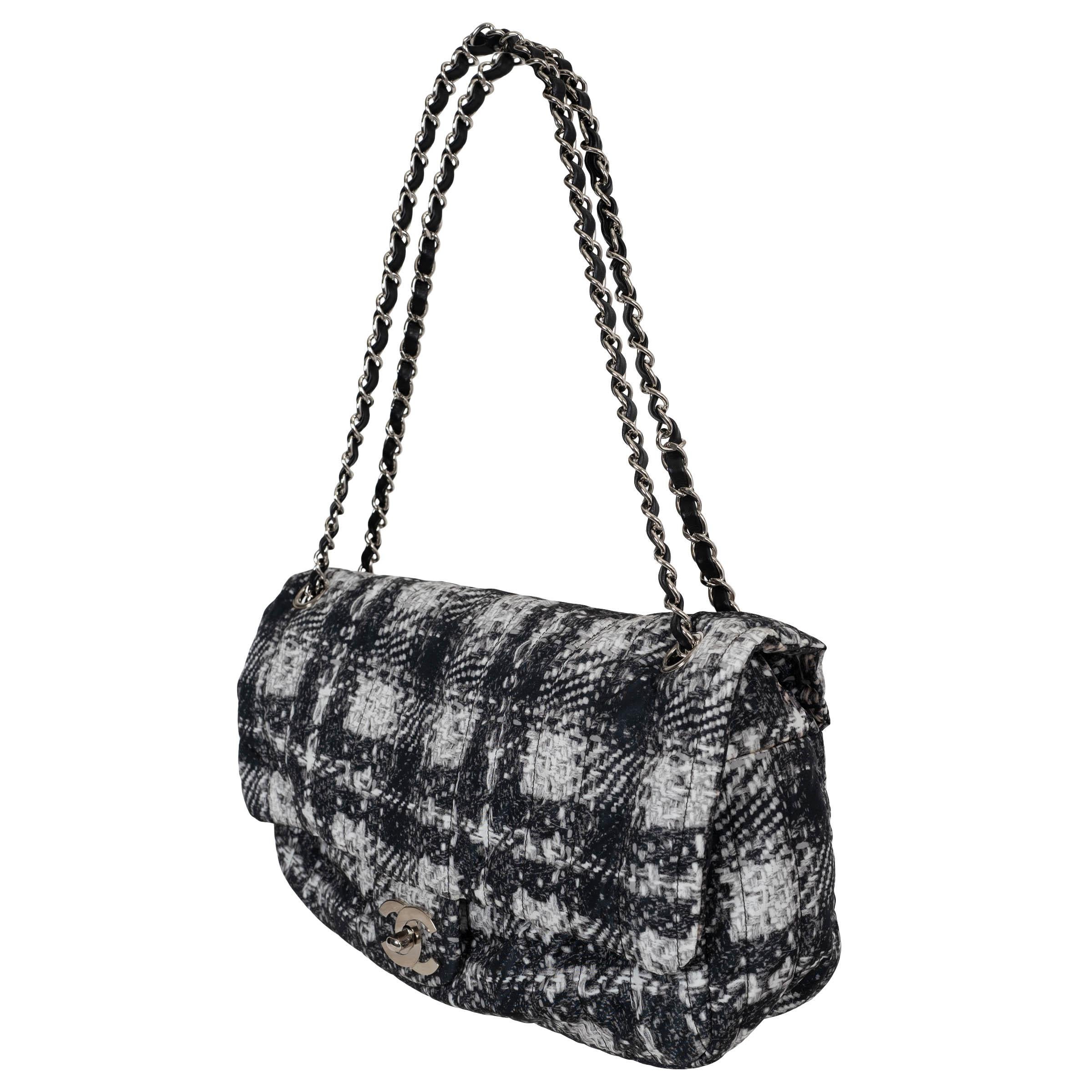 Este bolso con solapa Jumbo 100% auténtico de Chanel en nailon con estampado de tweed blanco y negro ofrece una versión moderna de un clásico atemporal. Con una correa de cadena plateada entretejida con piel negra, combina la elegancia con la