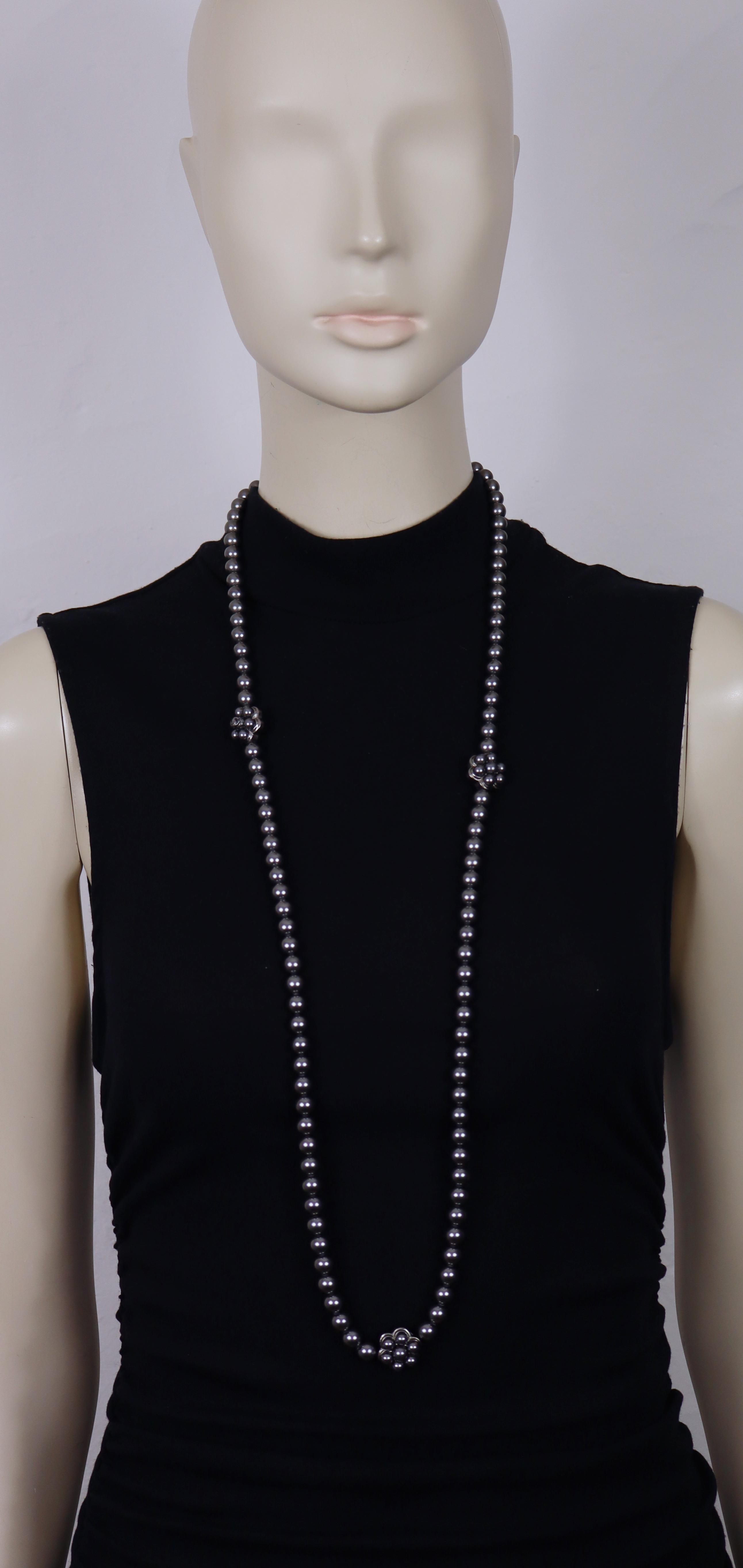 CHANEL necklace composed of a strand of grey faux pearls, accented on one side with three stylized flowers—each adorned with matching faux pearls, including one featuring a CC logo—and CC logos on the opposite side.

Ruthenium color metal