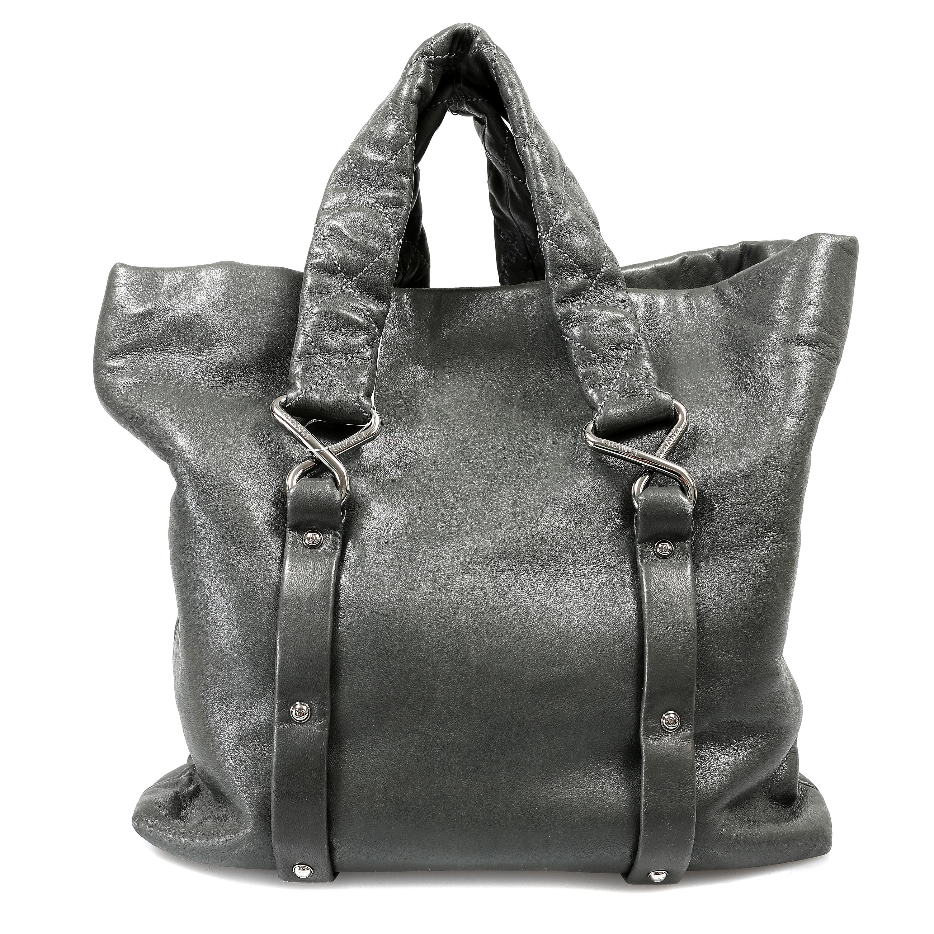 Questa autentica Tote Chanel in pelle d'agnello nera a otto nodi è in condizioni perfette.  Questo stile iconico è un'ottima borsa per l'uso quotidiano senza rinunciare a un briciolo di stile.
La tote in morbida pelle d'agnello nera è dotata di