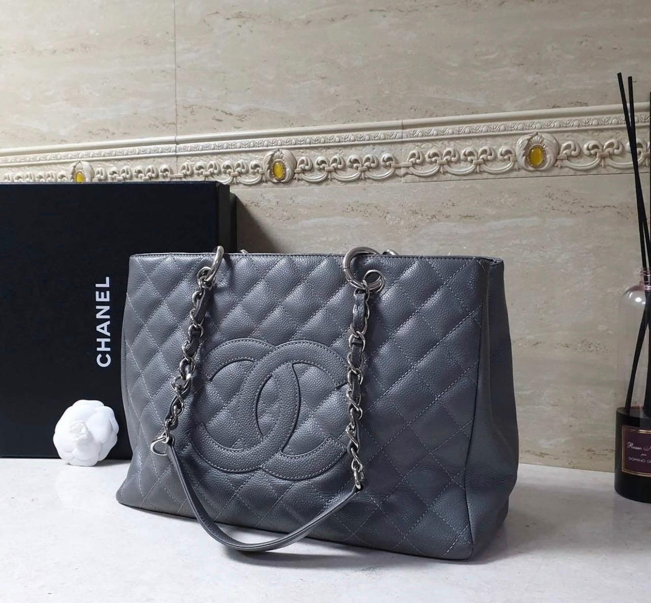 Es handelt sich um eine größere Version des klassischen GST und ist Teil der klassischen Kaviar-Kollektion von Chanel:: die ständig an Wert gewinnt. 
Diese Tasche ist aus wunderschönem:: gestepptem Kaviarleder mit einem auffälligen CC-Logo auf der
