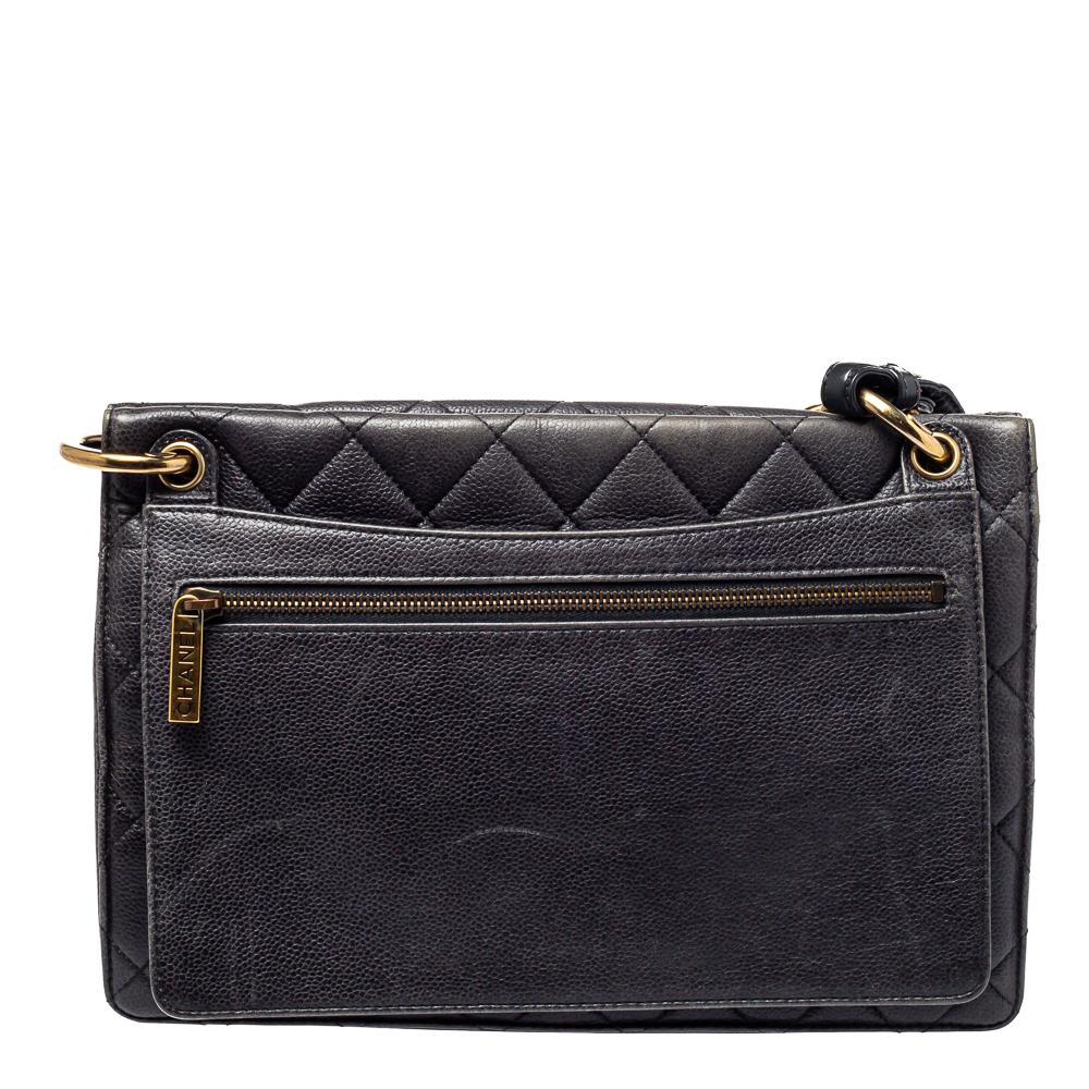This Chanel top handle bag in black is a fine piece of craft that will never go out of style. The bag is made from quilted Caviar leather and the front flap features the interlocking CC lock. This structured bag is designed to easily fit your