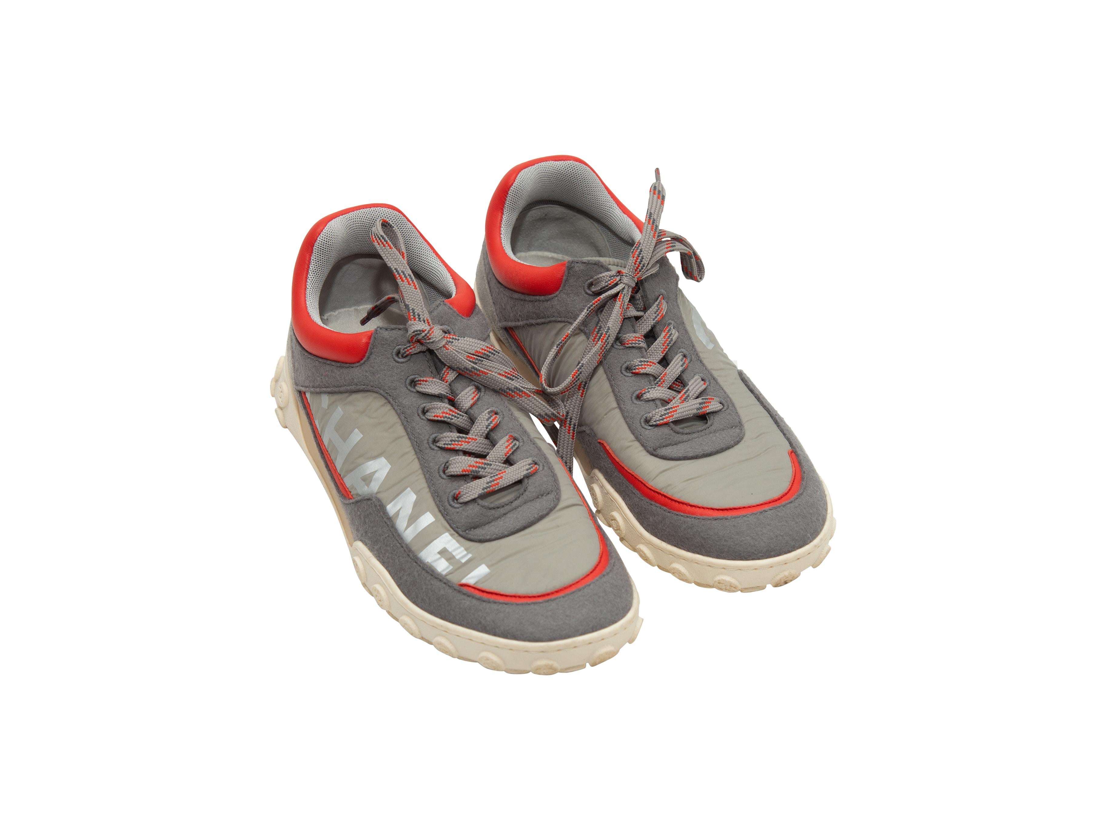 Product details: Grey and red fabric low-top sneakers by Chanel. Circa 2019. Leather and suede trim throughout. Rubber soles. Lace-up tie closures at tops. Designer size 39.5. 1