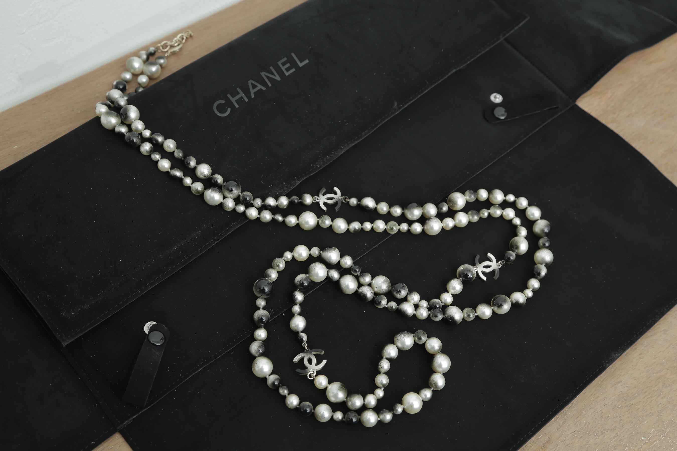 This elegant extra long necklace is crafted of smooth bi-colored faux pearls of various sizes and a dark silver Chanel Cc logos.  This necklace is long enough for triple strand.
32