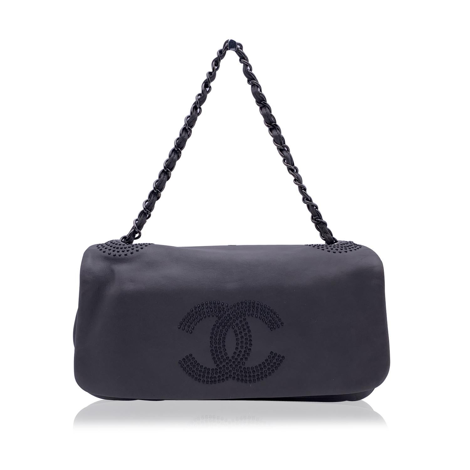 Chanel East West Schultertasche aus glattem grauem Lammleder mit auffälligem CC-Logo aus schwarzen Nieten auf der Vorderseite der Tasche und Nieten an der Basis der Griffe. Zeitraum/Epoche: 2008/2009. Beschläge aus Rotguss. Klappe mit CC -