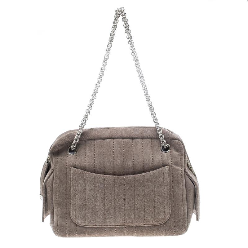 Crafted from suede, this grey piece from Chanel is sure to make a standout addition to your collection. The bag features a vertical stripe stitch detailing and interlocking chain shoulder straps. It flaunts a front and back pocket and the top zip