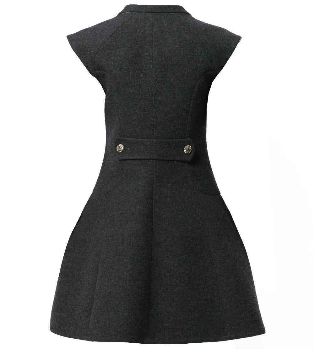 Beautiful Chanel grey silk blend vest-overcoat dress. It features a v-neck, a shawl lapel, a front button fastening, cap sleeves, side slit pockets, a flared style, a mid-length, a back buttoned strap and gold-tone and silver-tone flower embellished
