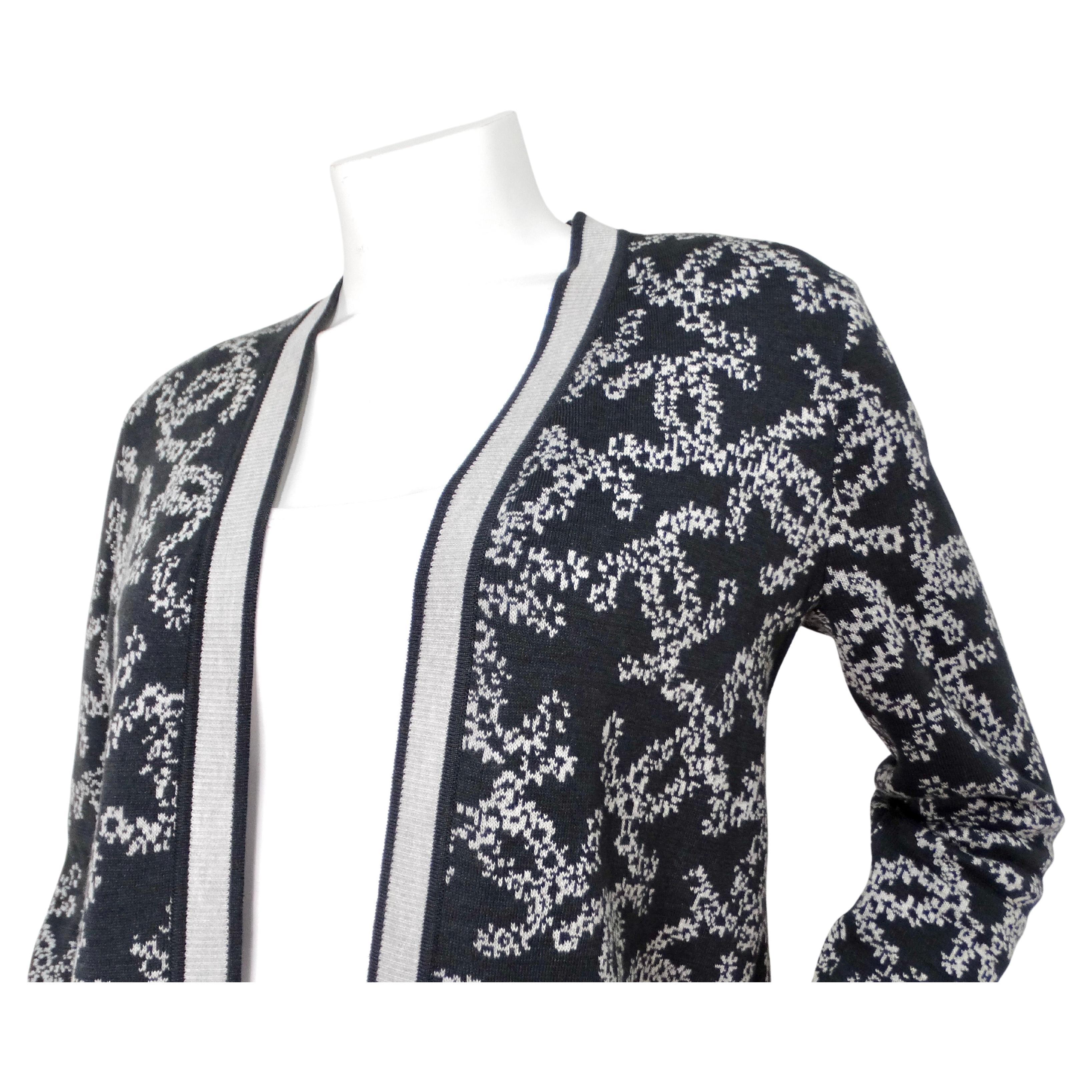 Le cardigan en maille à logo CC imbriqué gris et blanc de Chanel est une pièce sophistiquée et polyvalente qui incarne l'élégance intemporelle et le luxe moderne. Fabrice en coton de haute qualité, ce cardigan présente une palette de couleurs