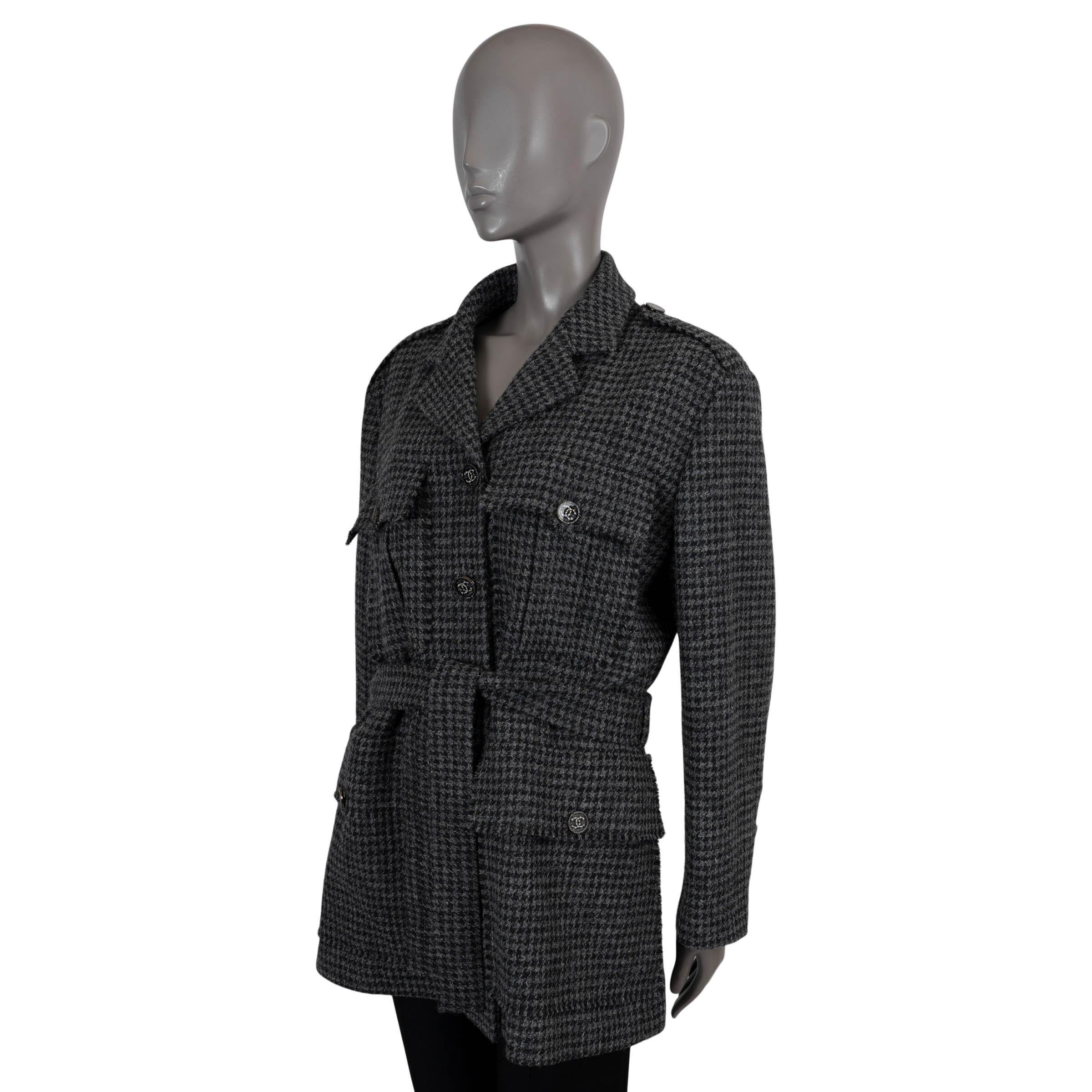 100% authentic Chanel houndstooth tweed jacket in black and grey wool (100%). Features buttoned epaulettes, notched lapels and four buttoned flap pockets. Closes with rhinestone encrusted CC buttons and a self-tie fabric belt on the front. Lined in