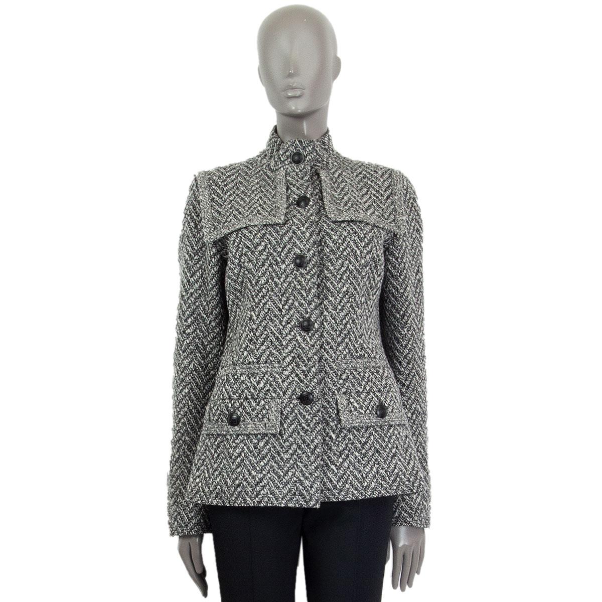 100% authentic Chanel knitted Herringbone jacket in black, white and light grey wool (90%) and nylon (10%). Features two flap pockets at front. Stand up collar. Opens with black matt CC embellished buttons and has zipped cuffs. Lined sleeves in