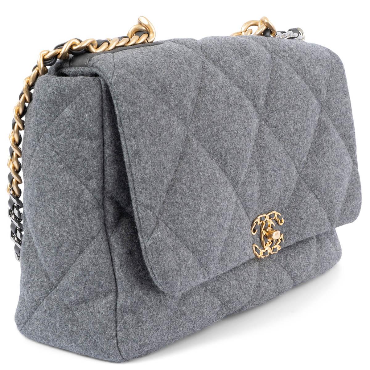100% authentic Chanel 19 Maxi Bag in grey wool featuring dark silver-tone, gold-tone and gunmetal hardware. The design comes with a chunky chainlink top-handle and shoulder-strap. Opens with a CC turn-lock to a grey grosgrain lined interior with one