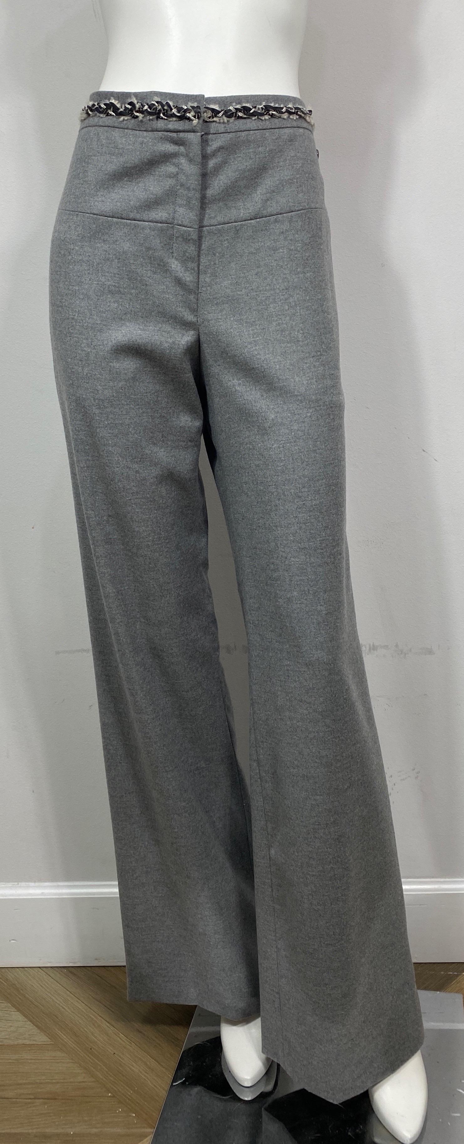 Chanel Grey Wool Wide Leg Pants-Size 42  The grey wool blend pants have a 6” front zipper with a hidden large hook and eye and button closure, a gunmetal textured oval cc ornament on the top front left hip area, and a woven black leather/white