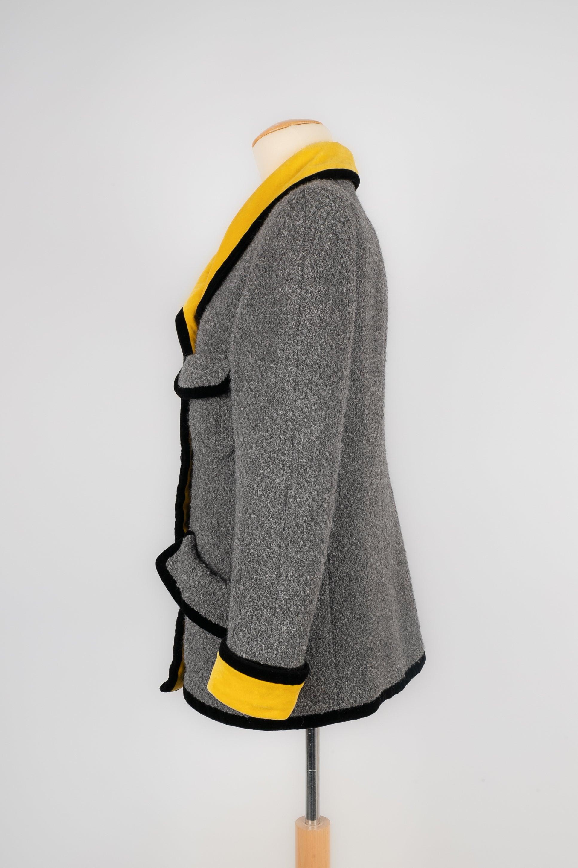 Chanel - Grey woolen jacket with yellow and black velvet. No size indicated, it fits a 36 FR.

Additional information:
Condition: Good condition
Dimensions: Shoulder width: 38 cm - Chest: 47 cm - Sleeve length: 60 cm - Length: 65 cm

Seller